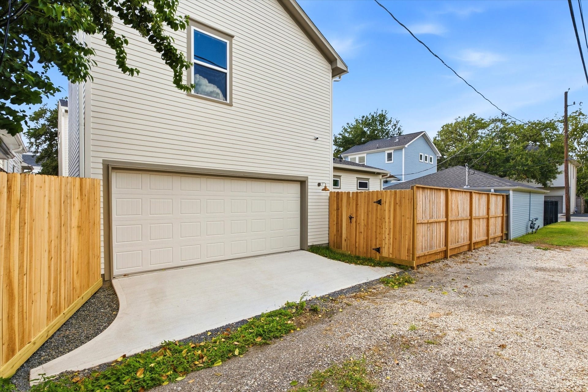Convenient alley access leads to the two-car garage, with the property enclosed by brand-new fencing for added privacy.