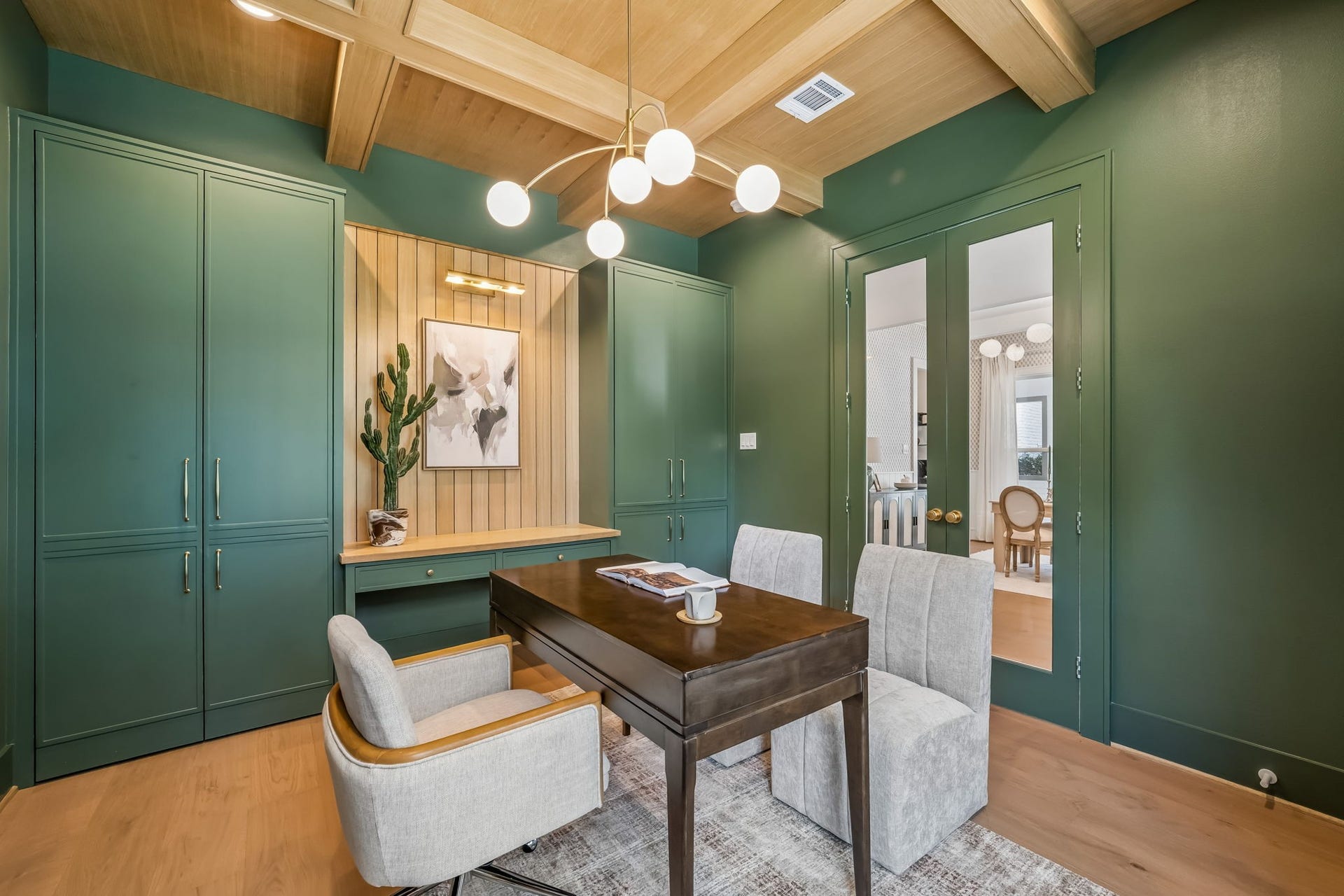 This elevated home office pairs warmth and function with white oak ceilings and custom built-ins offering beautifully integrated storage. Hidden behind a second set of built-ins, a discreetly concealed panic room adds an unexpected layer of privacy and security.