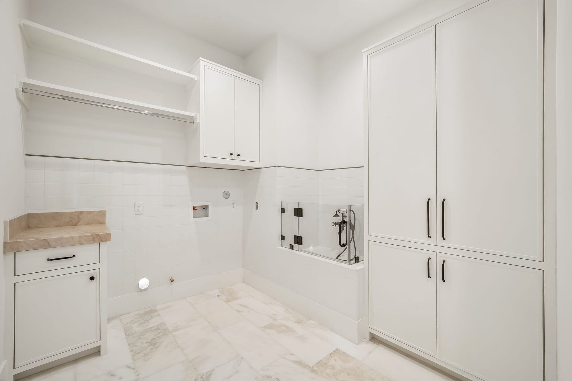 Second-floor laundry room offering ample storage and a dedicated dog wash for added convenience!