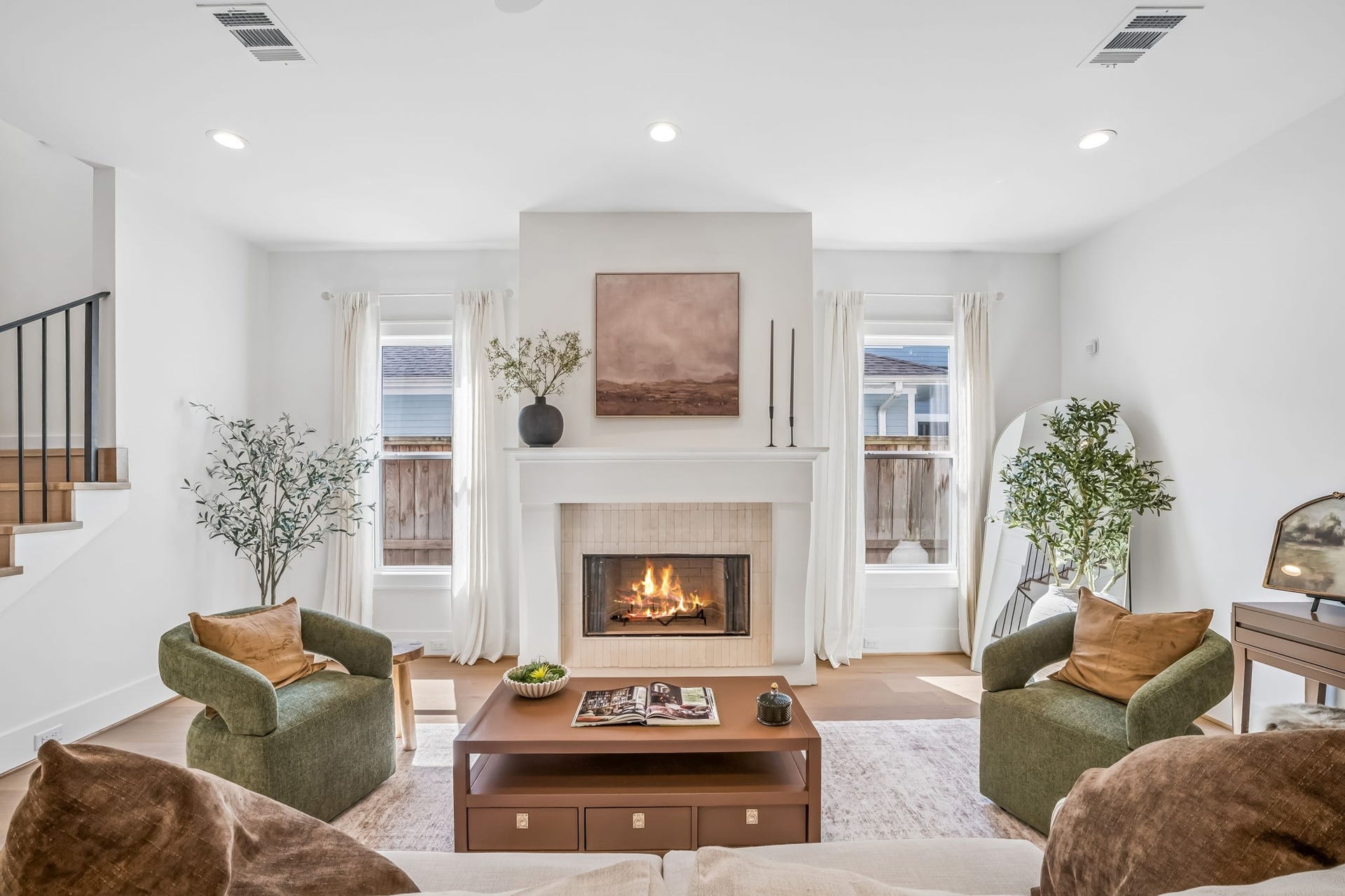 The inviting living room feels warm and refined, anchored by a stunning wood-burning fireplace with a custom stucco finish.
