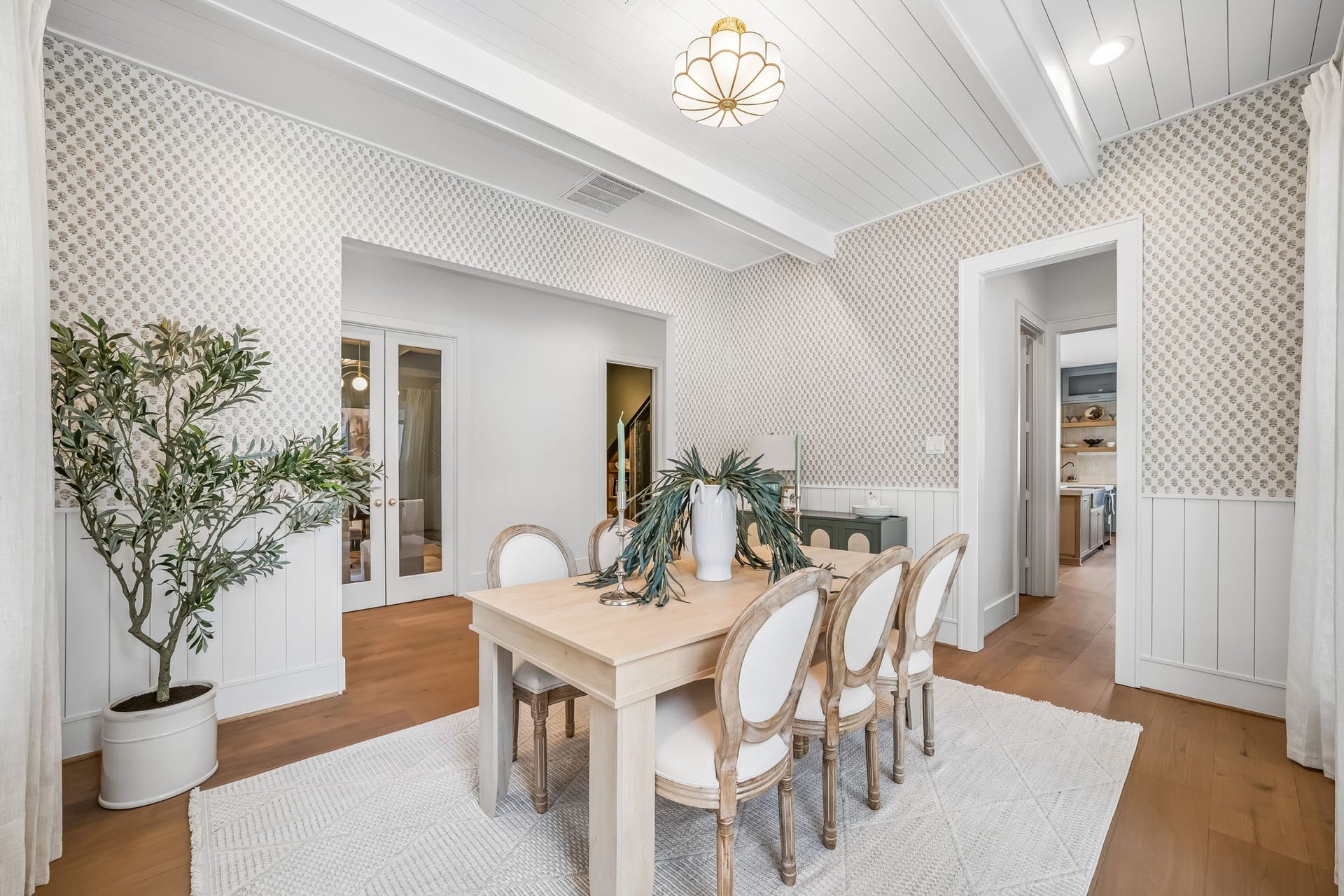 Alternate view of the dining area, highlighting the Phillip Jeffries wallpaper, custom shiplap detailing, and warm natural light.