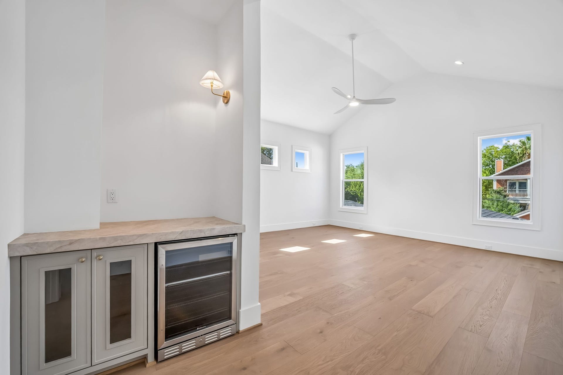 Built-in beverage fridge with glass-front cabinetry and a stone countertop, creating a sleek, functional refreshment station.