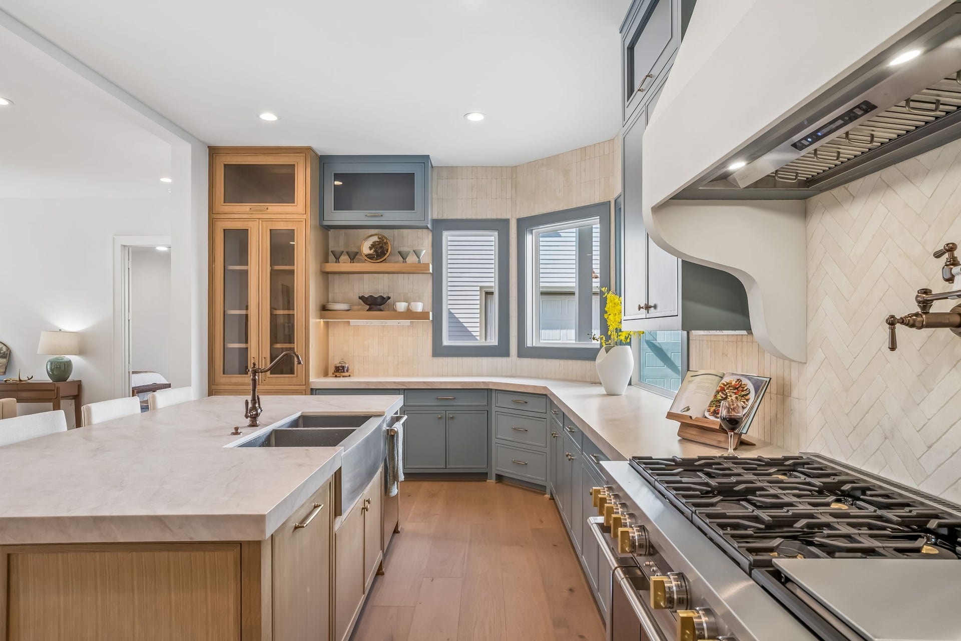 The kitchen of your dreams comes to life with custom white oak and dusty blue inset cabinetry, a full suite of Monogram appliances, and leathered Taj Mahal quartzite countertops. Thoughtfully designed with elevated finishes throughout, this space is equal parts beautiful and functional.