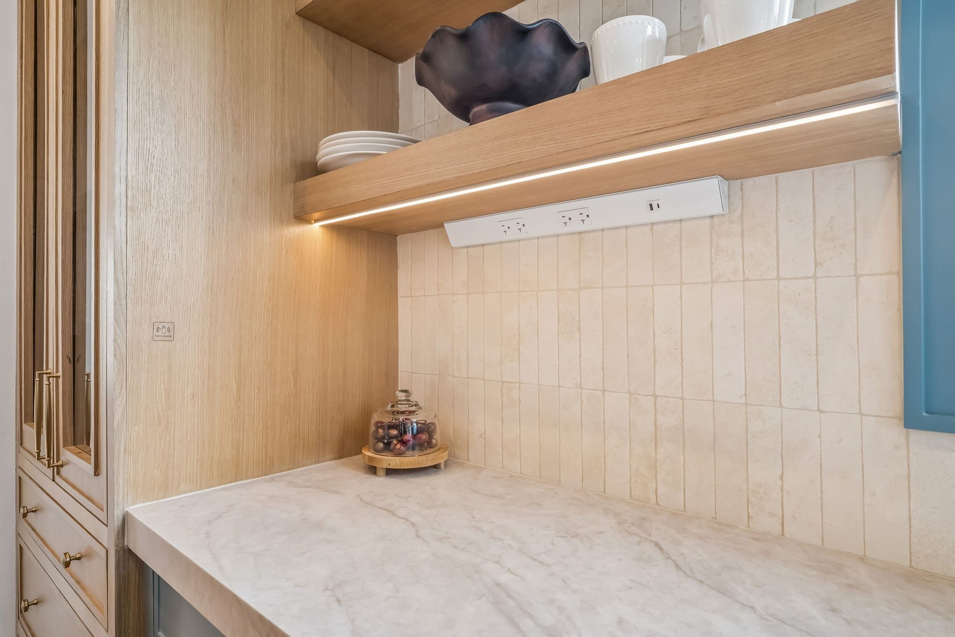 Concealed outlets and integrated under-cabinet lighting allow the backsplash to remain beautifully uninterrupted, creating a clean, seamless finish throughout the kitchen.