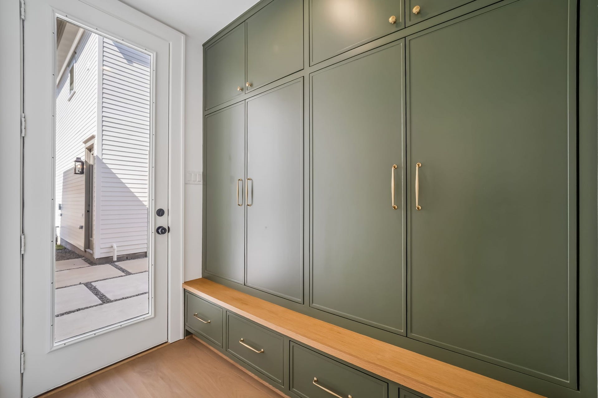 The much-needed first floor mudroom offers thoughtfully designed closed storage with outlets and adjustable shelving inside, creating a dedicated space to keep everyday essentials organized and tucked neatly out of sight.