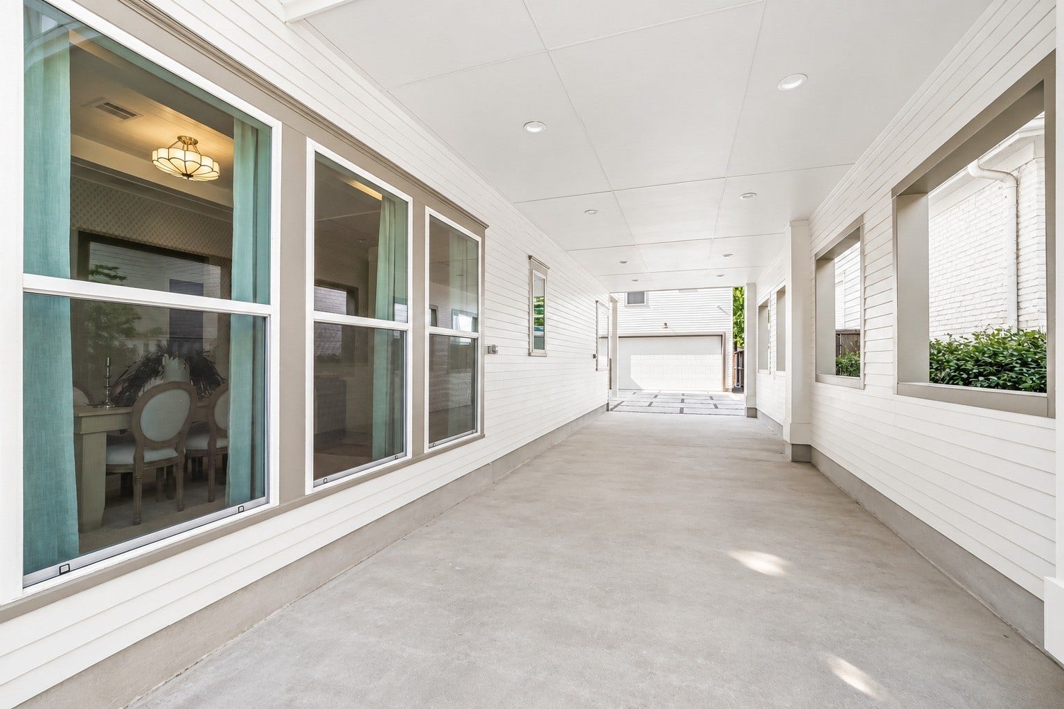 Expansive covered portico alongside the home offers endless possibilities for additional parking or outdoor living and entertaining