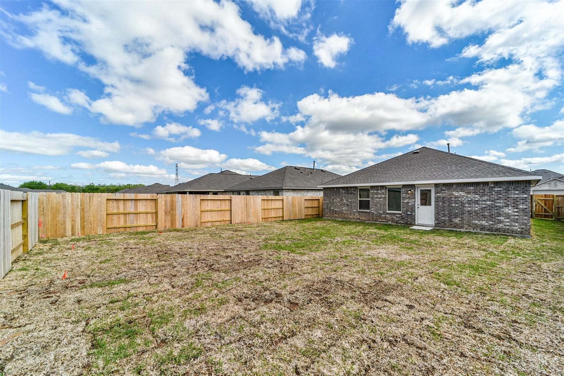 Great-sized private backyard featuring lush green grass and a beautiful, fully enclosed fence.