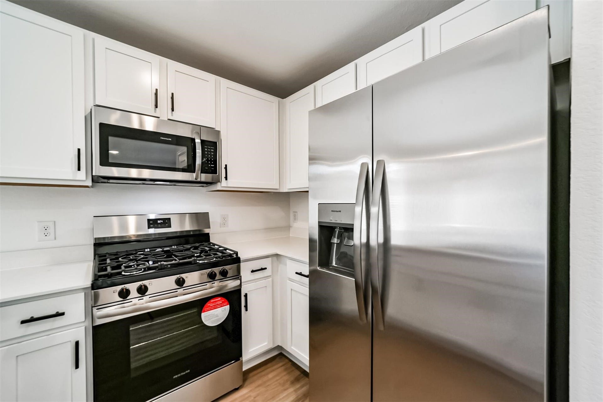 Modern kitchen equipped with stainless steel appliances, including a refrigerator and built-in microwave.