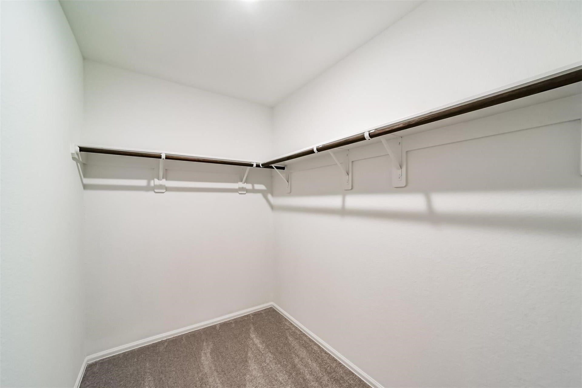 Massive primary walk-in closet with custom shelving and plenty of storage space.