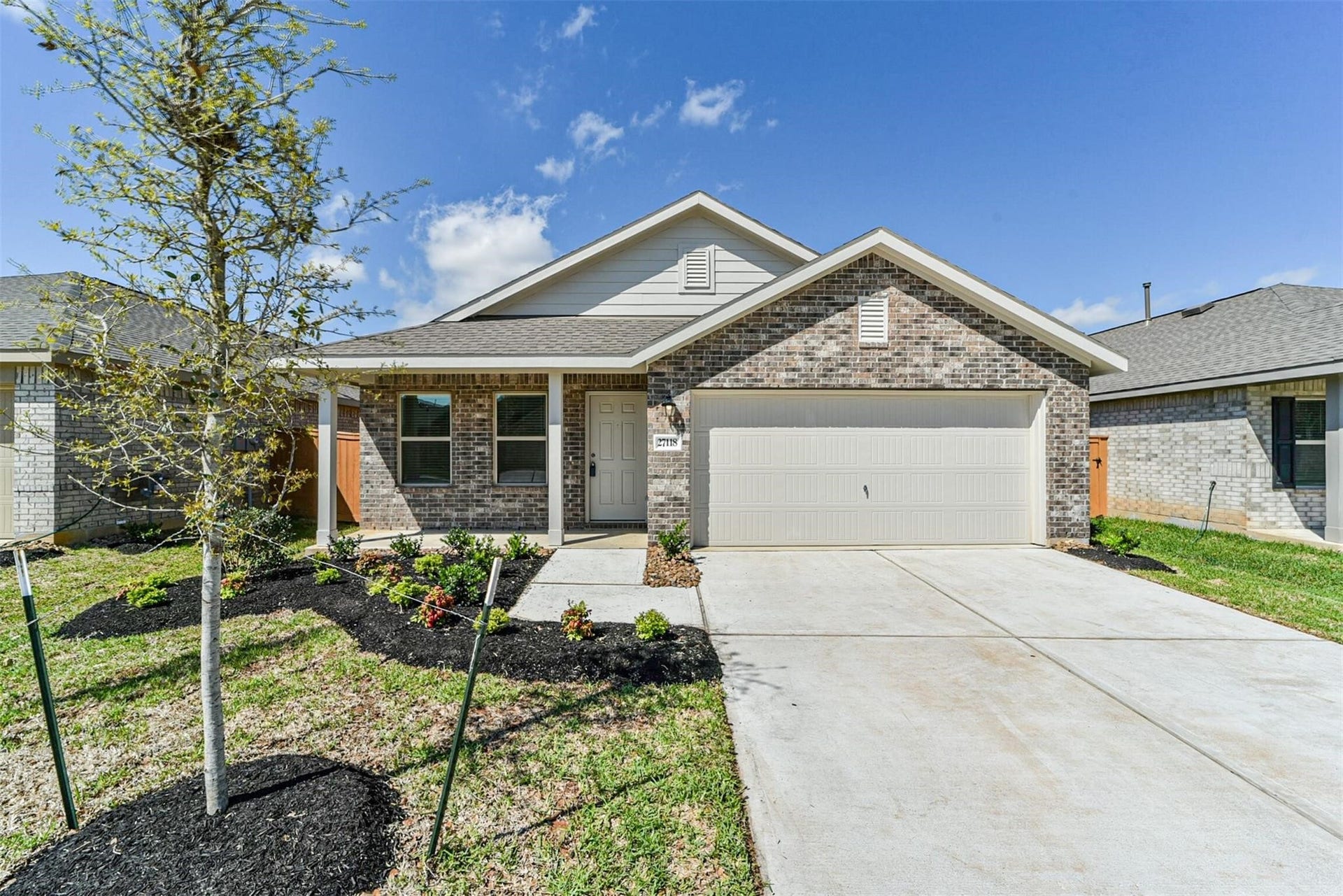 Welcome Home. Front exterior view featuring professional landscaping and a charming brick and stone elevation.