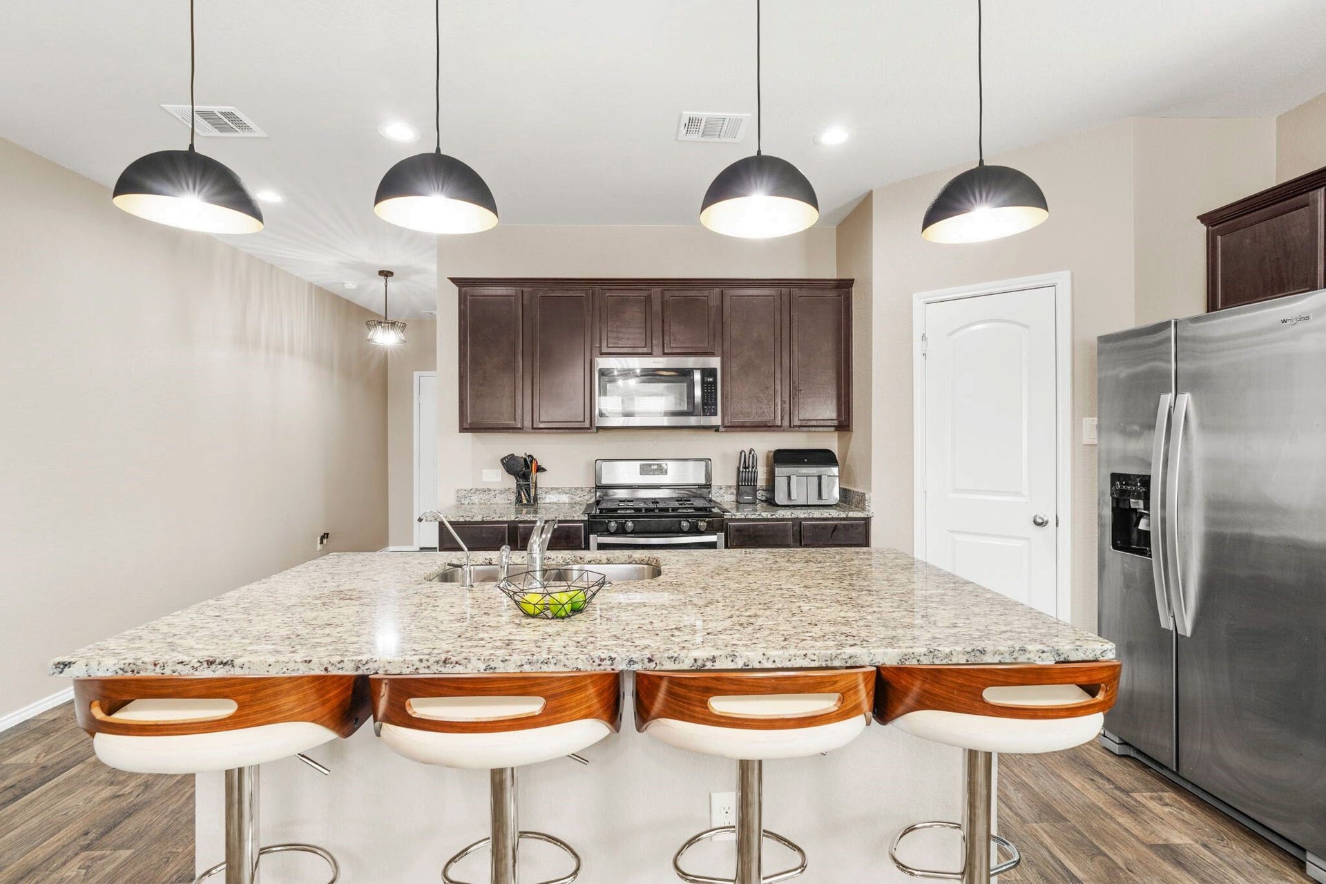 22624 Theodoli Drive, Katy, TX 77449 A stylish lighting fixture hangs over the kitchen island, adding a touch of elegance and highlighting the space.