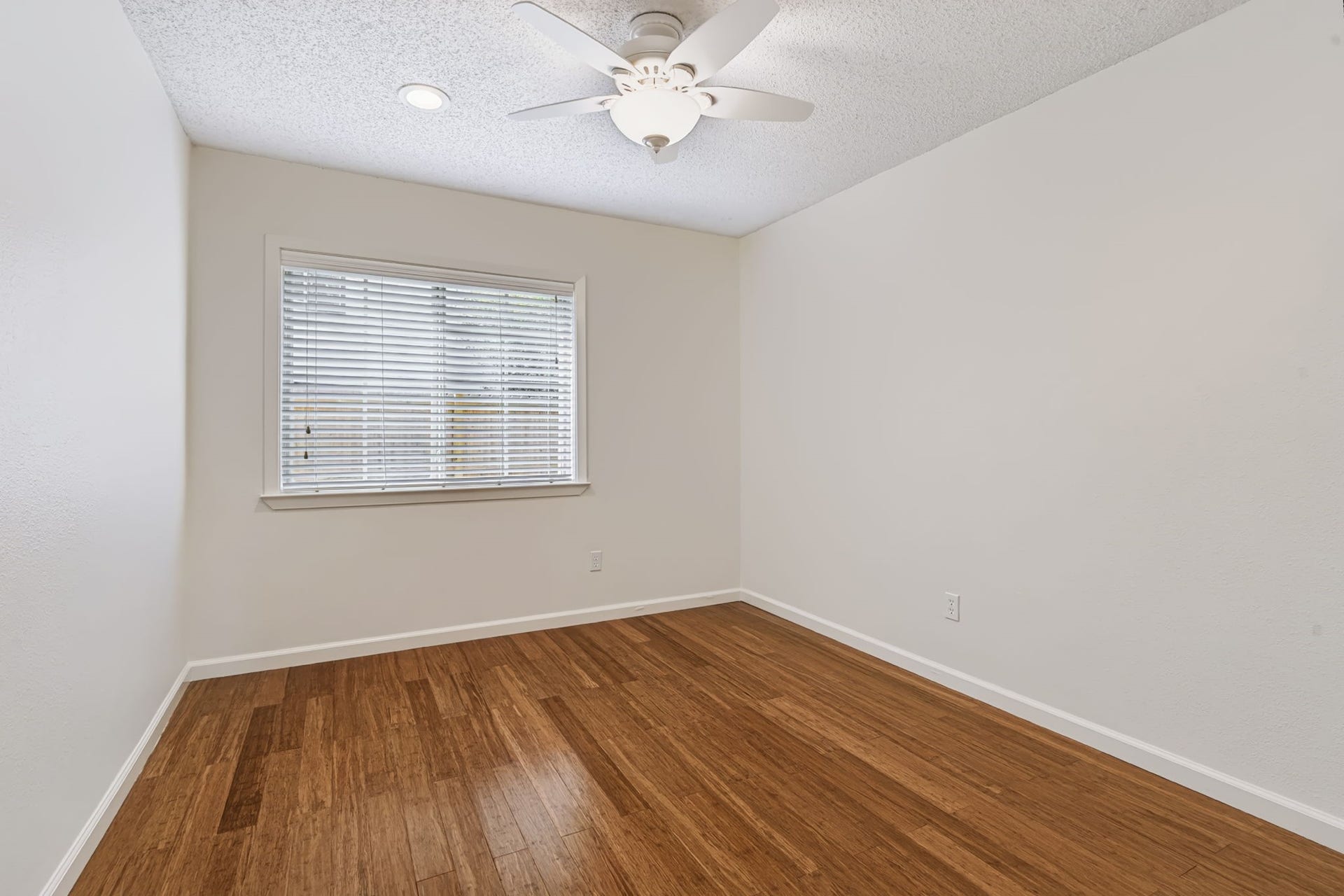 1802 Brushy Creek Drive, Sugar Land, TX 77478 One of two secondary bedrooms, this inviting space features bamboo wood flooring, two closets, a lighted ceiling fan, and a large window that welcomes in natural light.