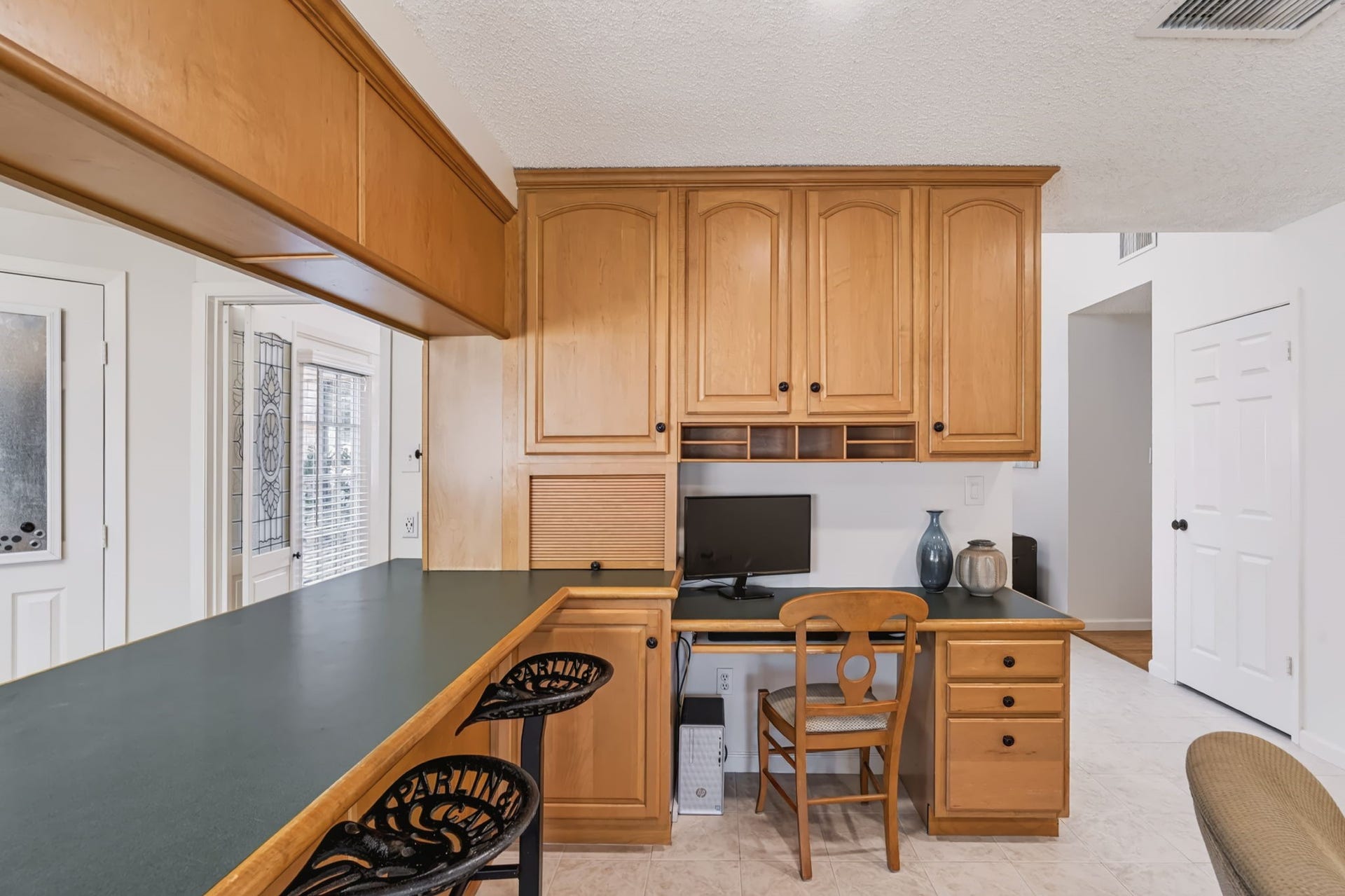 1802 Brushy Creek Drive, Sugar Land, TX 77478 Situated between the kitchen and family room, the built-in desk features custom cabinetry, drawers, and cubbies, creating a functional workspace with plenty of organized storage.