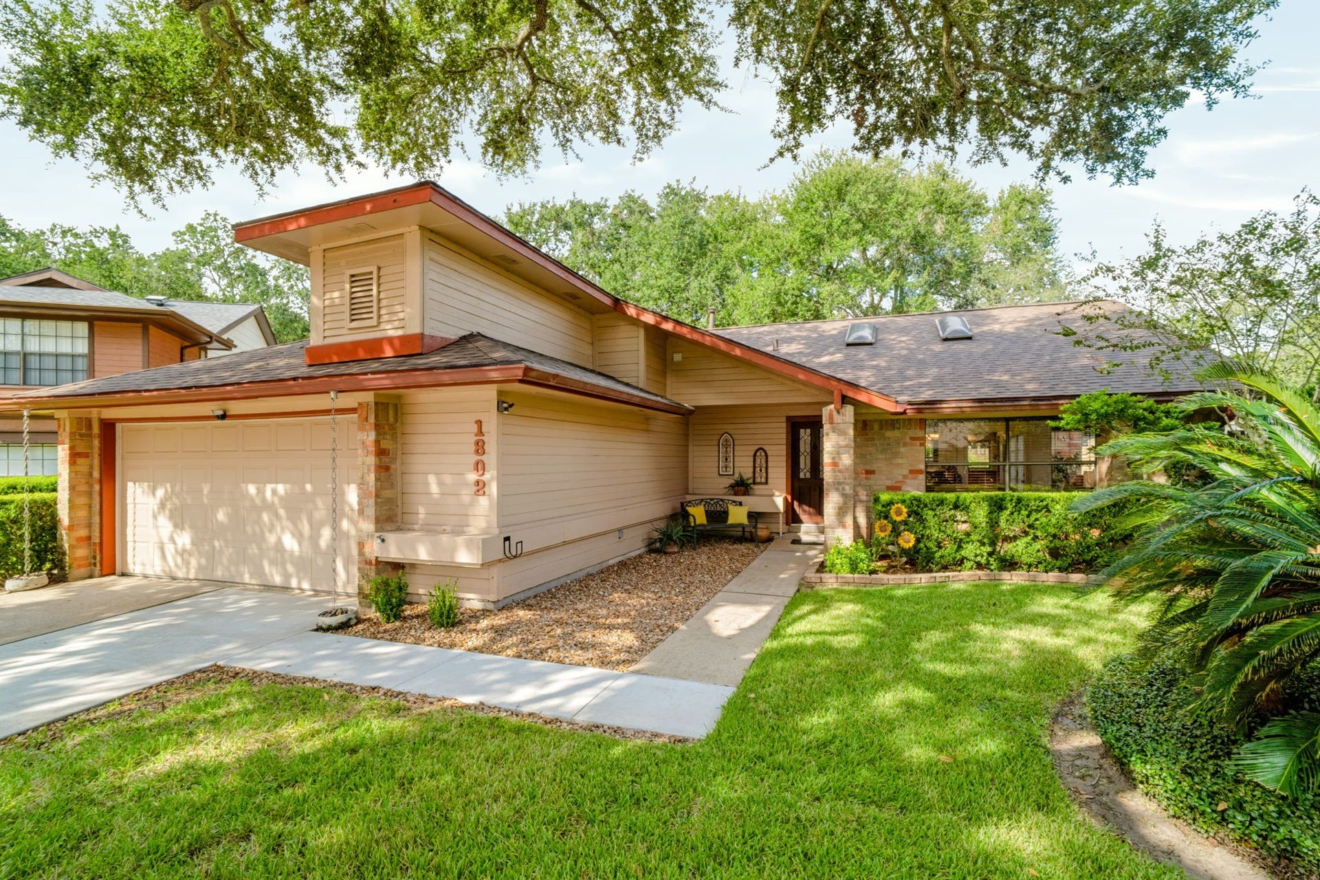 1802 Brushy Creek Drive, Sugar Land, TX 77478 Beautifully maintained front landscaping and a welcoming front porch create inviting curb appeal, reflecting the care and attention given to the property.