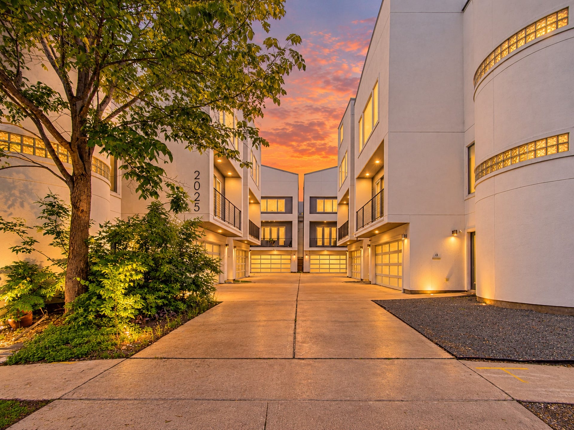 2025 Colquitt Street, #E, Houston, TX 77098 Gated driveway leading into the community, with illuminated architectural details and landscaped surroundings.
