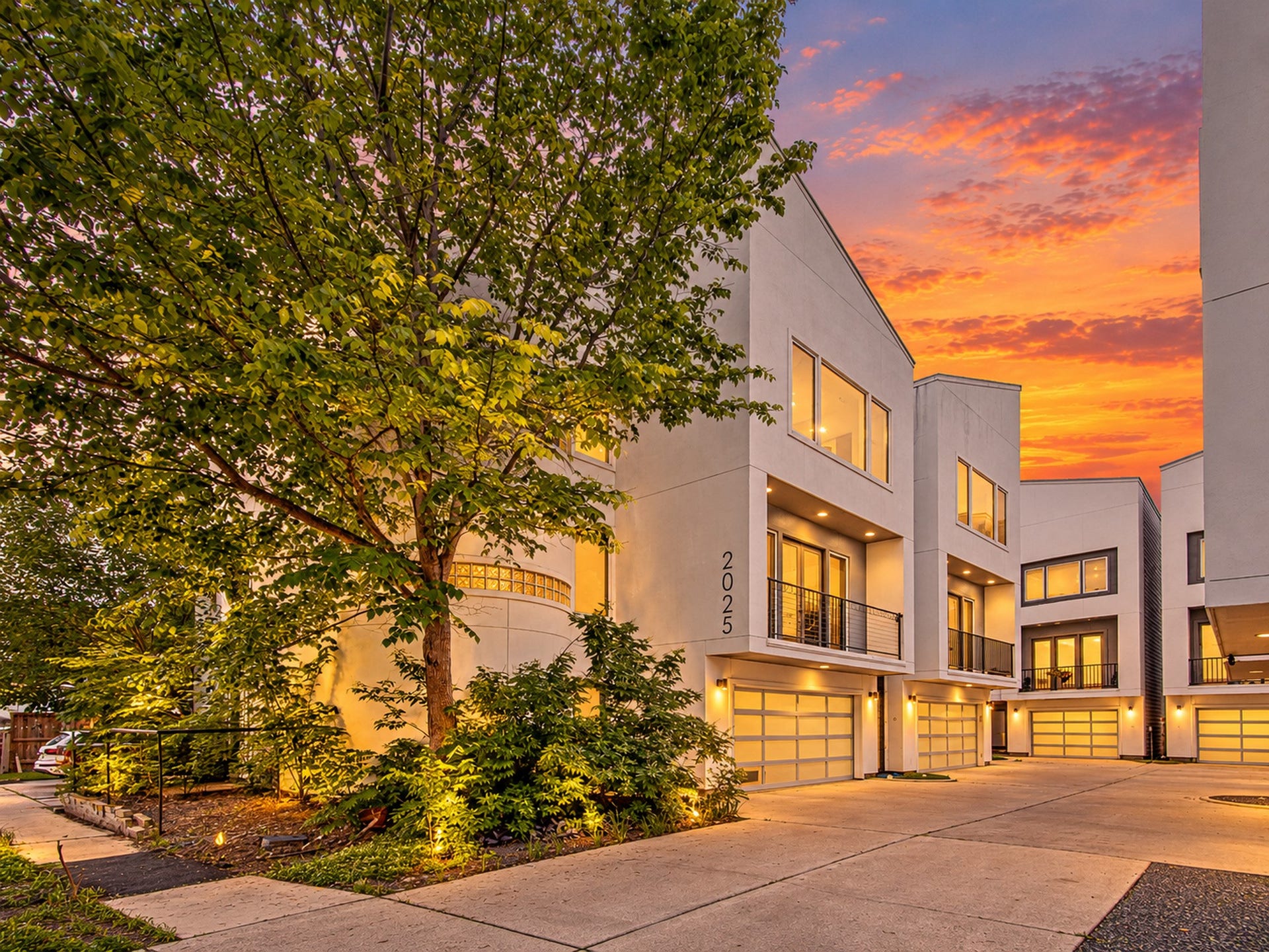 2025 Colquitt Street, #E, Houston, TX 77098 Mature trees and landscaped beds frame the approach to the home and its attached garage.