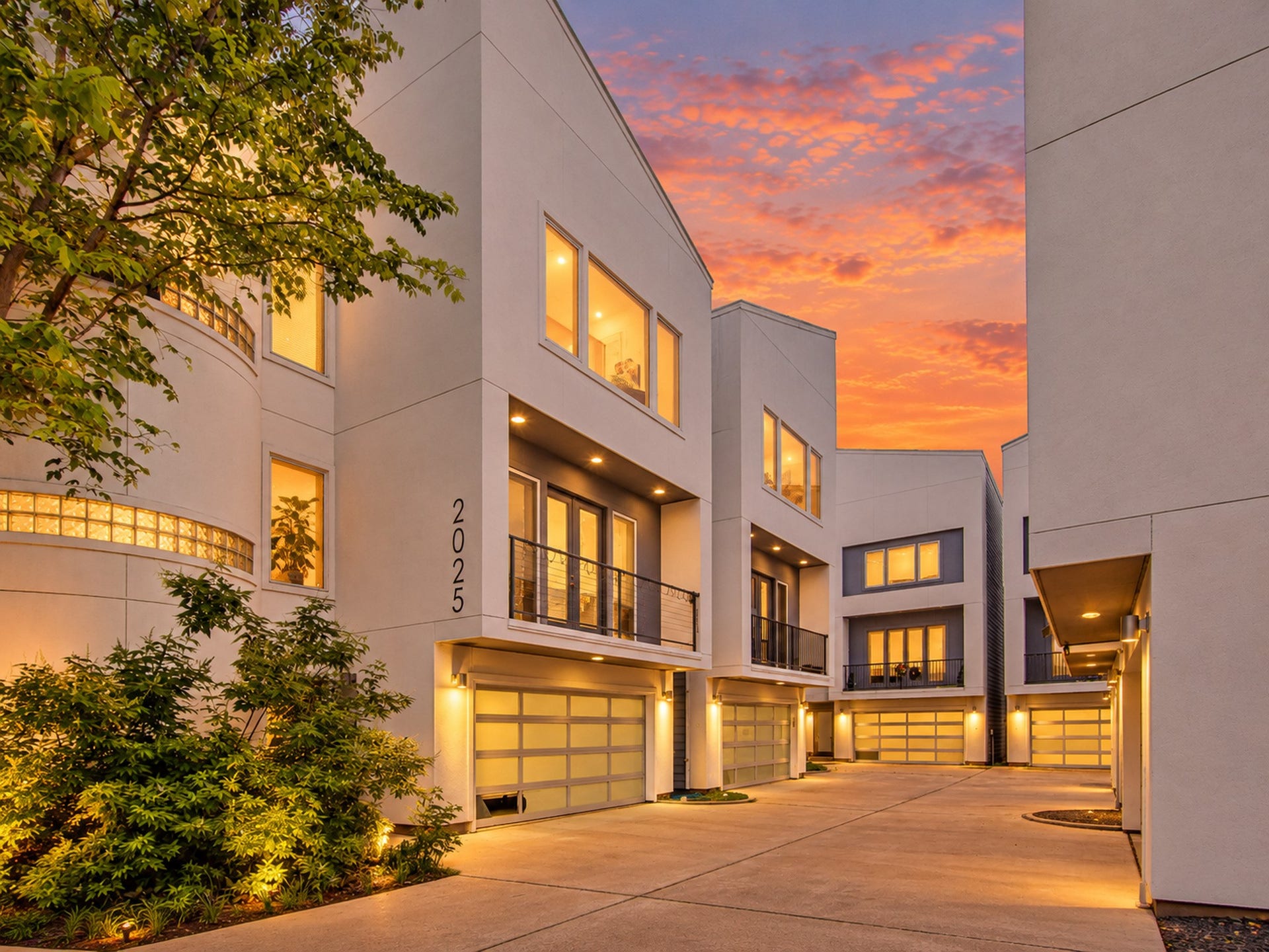 2025 Colquitt Street, #E, Houston, TX 77098 Exterior view highlighting expansive windows, a glass-paneled garage door, and contemporary architectural lines.