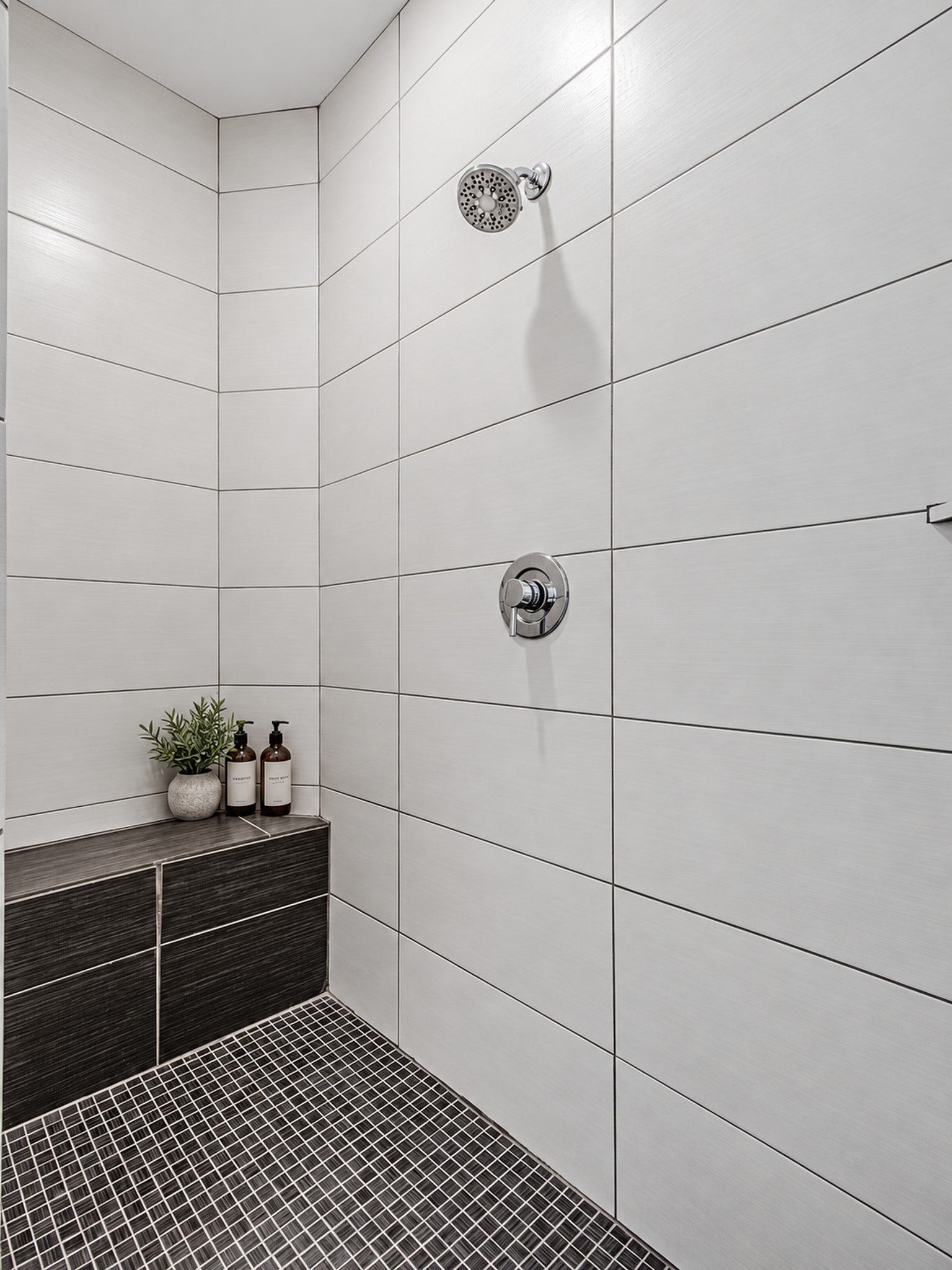 2025 Colquitt Street, #E, Houston, TX 77098 Walk-in shower featuring large-format wall tile, contrasting floor tile, and a built-in bench.