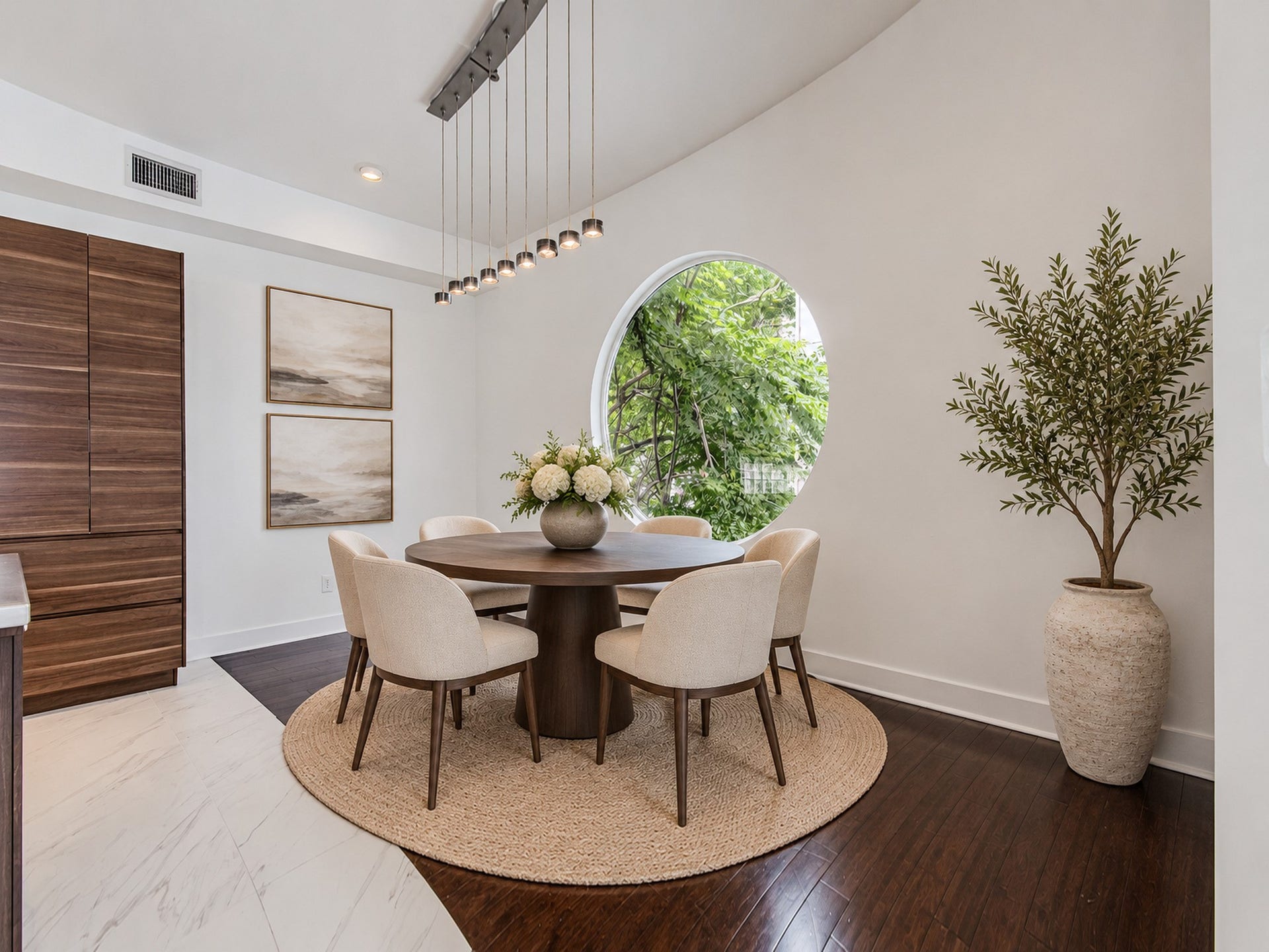 2025 Colquitt Street, #E, Houston, TX 77098 Dining area framed by a distinctive circular window, with wood flooring and convenient access to the kitchen.