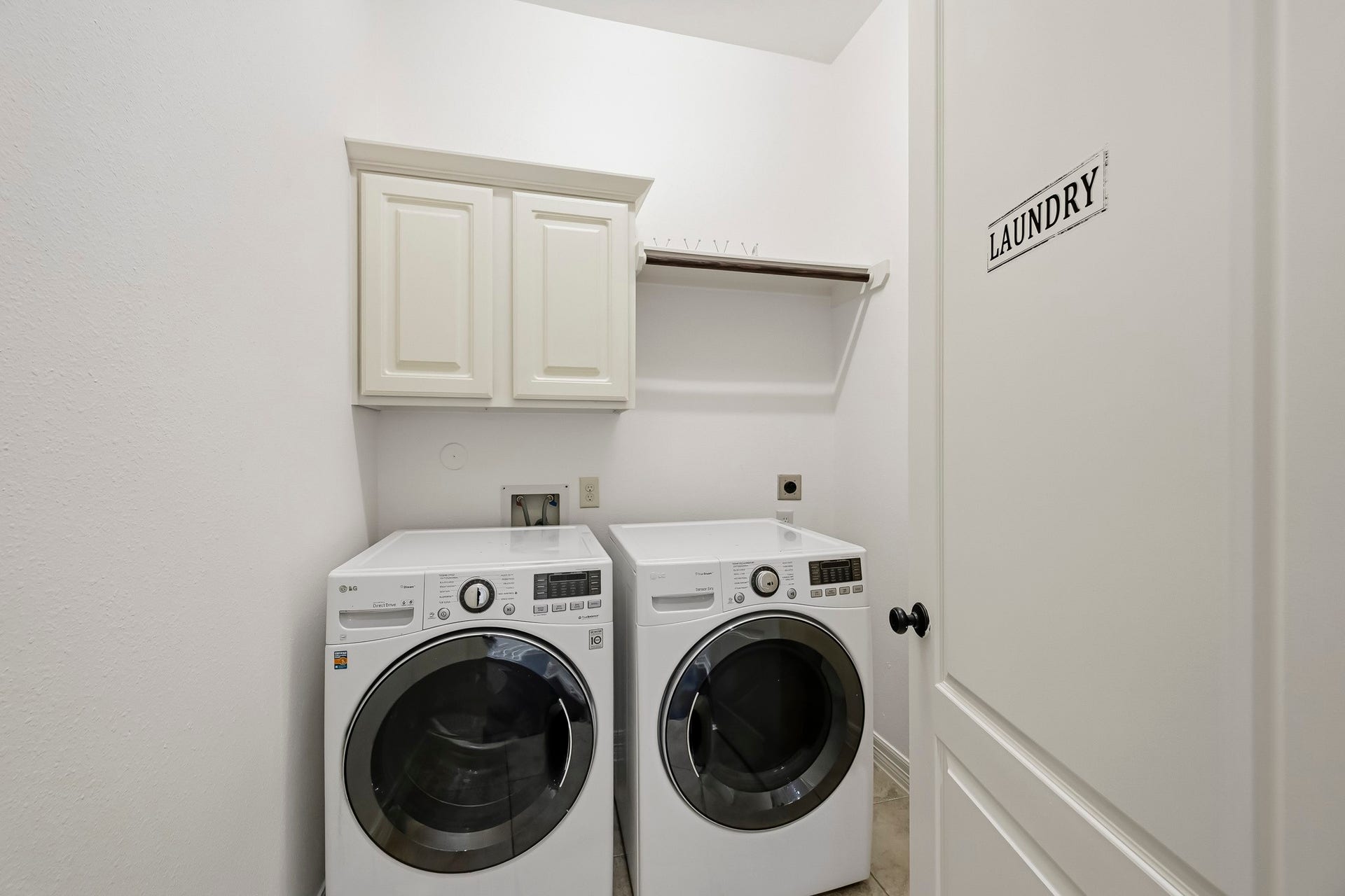27730 Dalton Bluff Court, Katy, TX 77494 This dedicated laundry room features a full-size front-loading washer and dryer with convenient overhead cabinetry for additional storage.