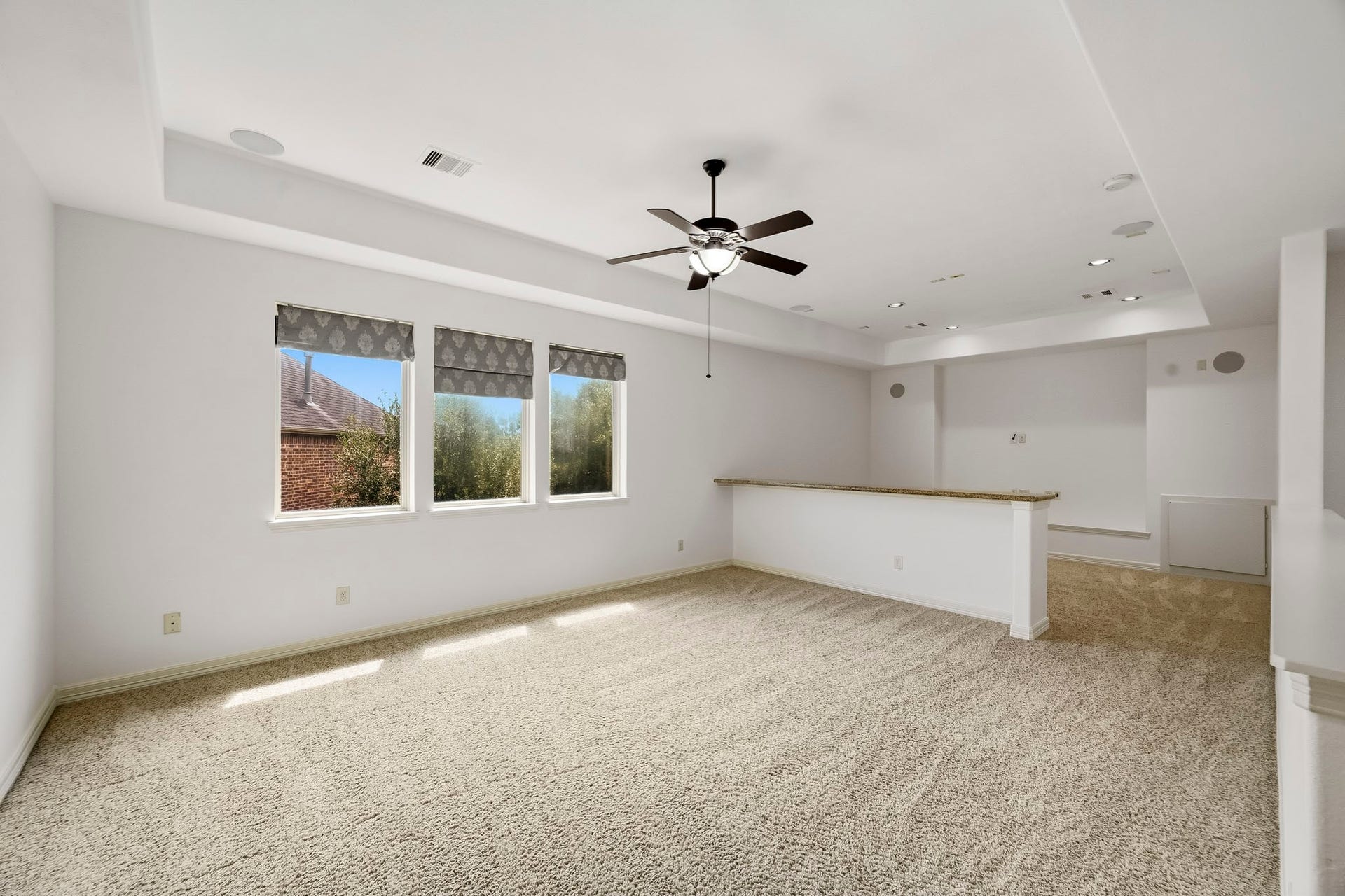 27730 Dalton Bluff Court, Katy, TX 77494 This expansive upstairs game room offers a generous open layout with plush carpeting and abundant natural light from multiple windows. A ceiling fan, recessed lighting, built-in speakers, and a convenient counter area enhance the space, while the flexible design provides plenty of room for a media setup, game tables, lounge seating, or additional entertainment areas.