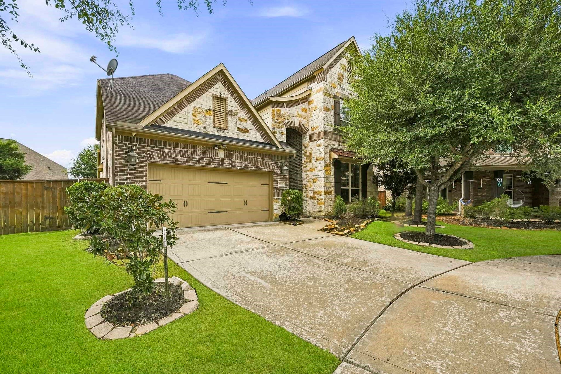 27730 Dalton Bluff Court, Katy, TX 77494 This impressive two-story home offers beautiful curb appeal with a striking combination of stone and brick exterior finishes. A spacious two-car garage and extended driveway provide ample parking. Architectural details, including varied rooflines, arched accents, and a covered front entry, add character to the homes inviting exterior.