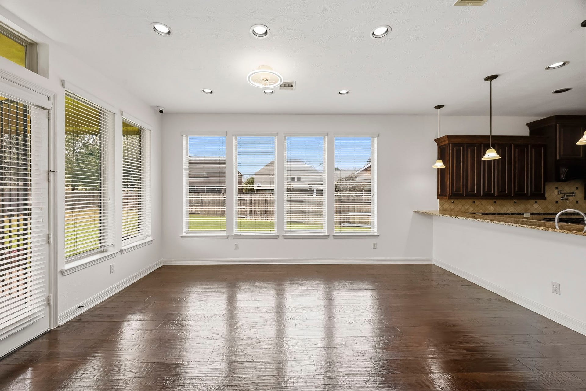 27730 Dalton Bluff Court, Katy, TX 77494 This bright and spacious dining area features rich hardwood flooring and an impressive collection of large windows that fill the space with natural light and offer views of the backyard. The open layout provides ample room for a generous dining table and flows seamlessly into the adjoining kitchen, making it ideal for both everyday meals and entertaining. Recessed lighting and direct access to the outdoor area further enhance the spaces inviting and functional design.