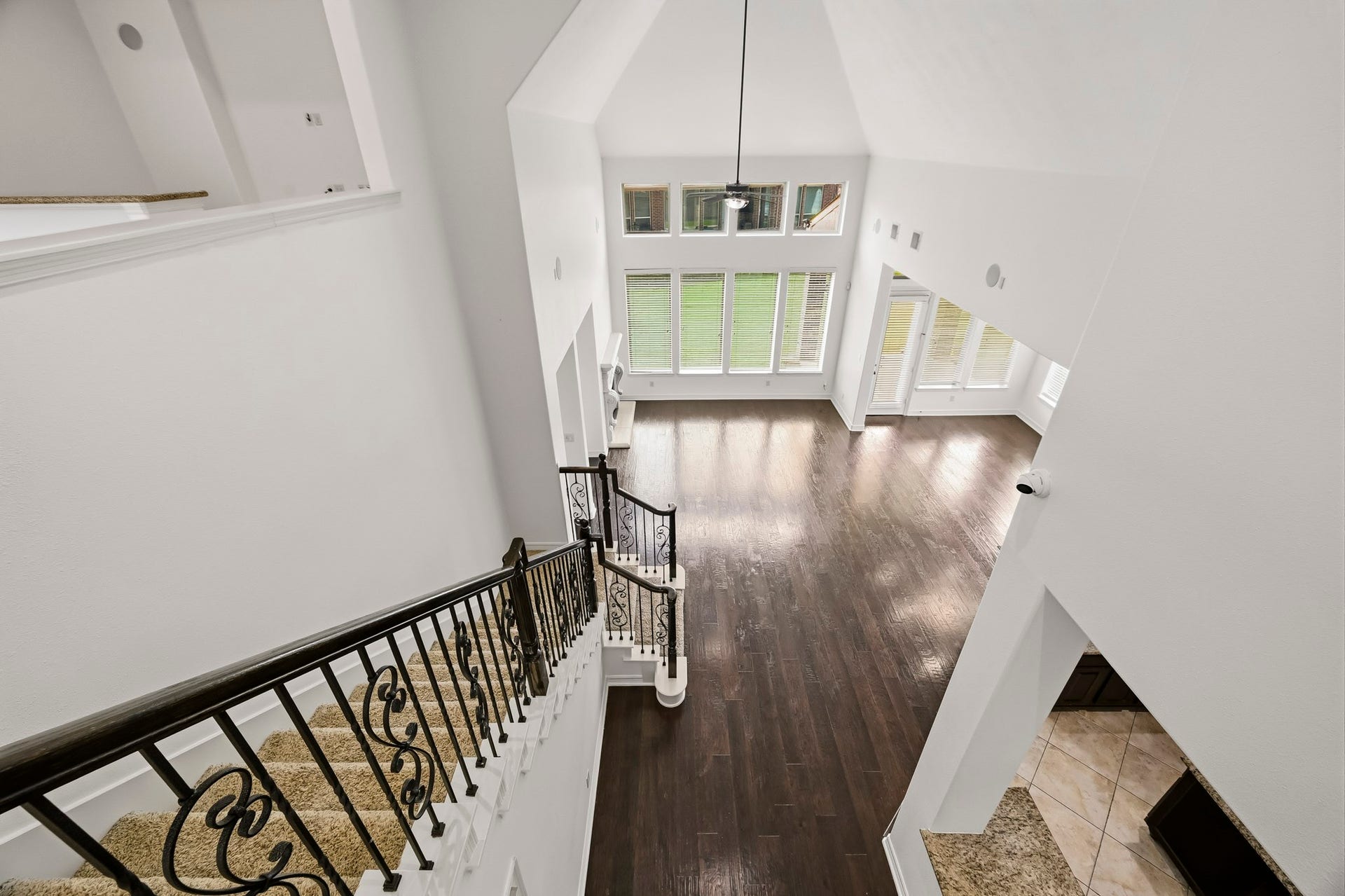 27730 Dalton Bluff Court, Katy, TX 77494 This impressive staircase serves as a striking architectural focal point, featuring dark wood handrails, decorative wrought-iron balusters, and carpeted steps that create an elegant contrast against the bright interior.