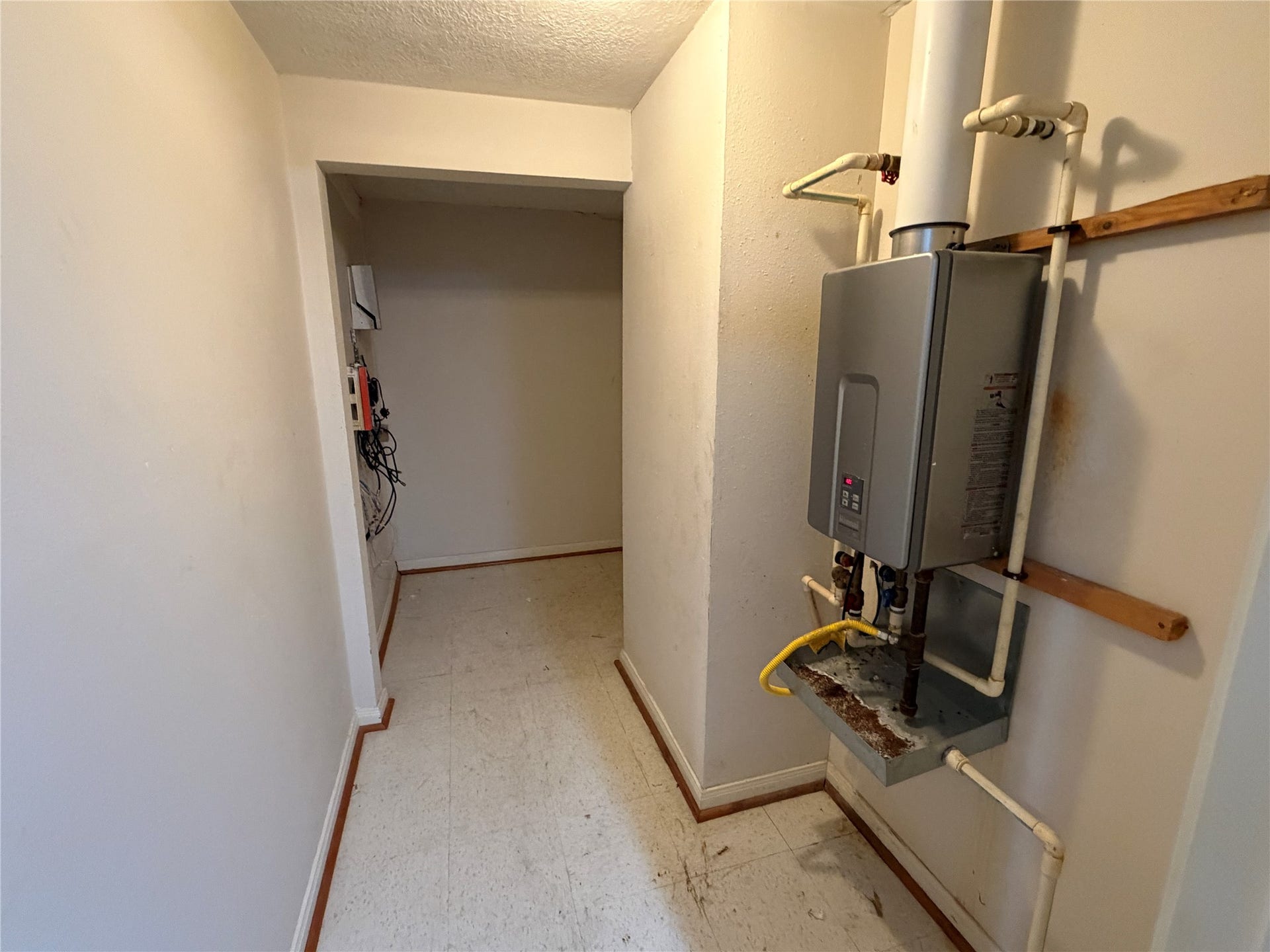 The hallway/ storage area with the water heater and access to the large attic storage space.