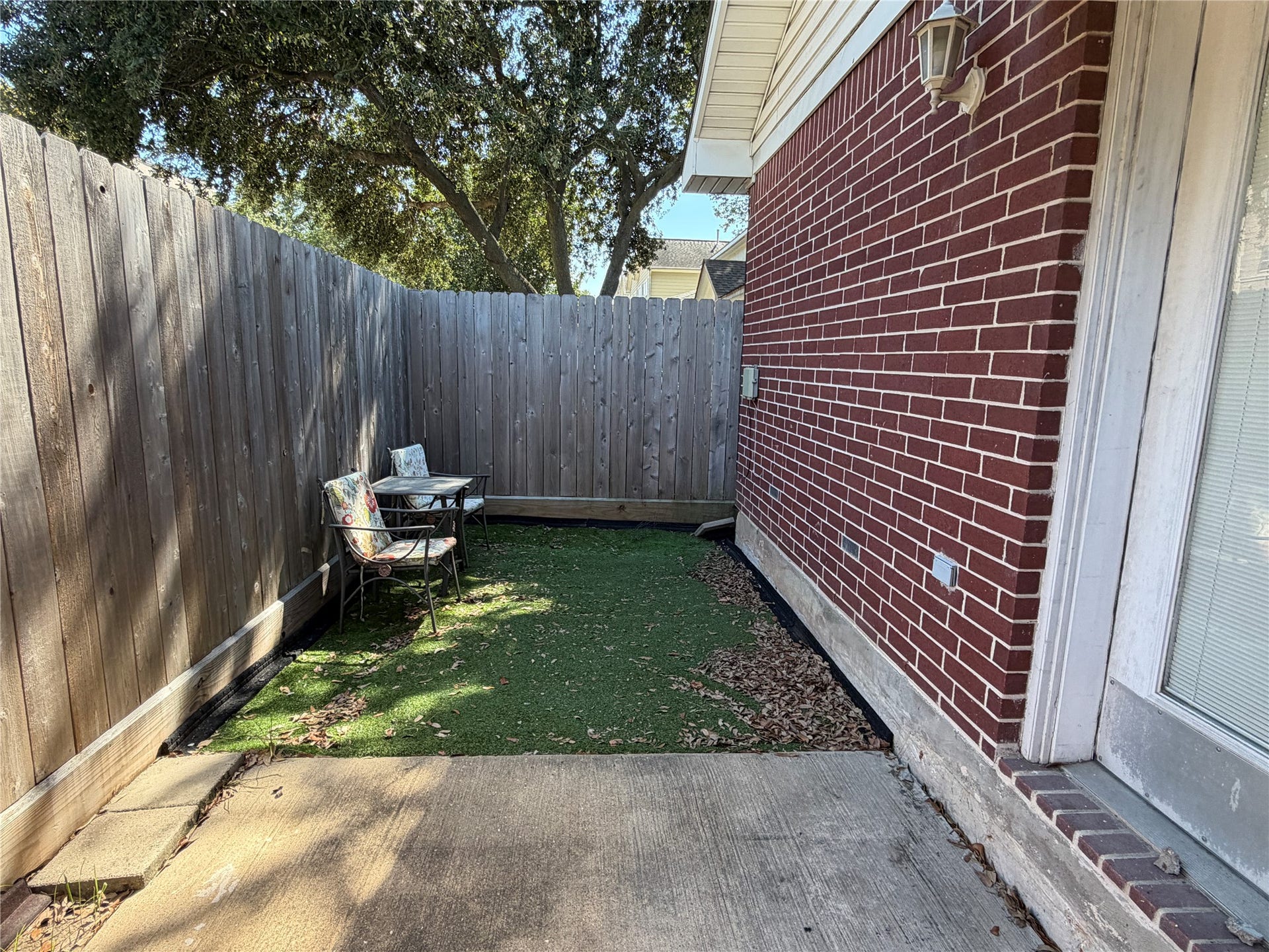 The fenced back porch has astroturf for easy maintenance.