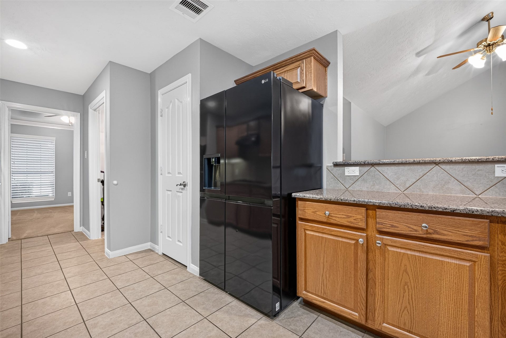 Additional kitchen view featuring generous cabinetry, countertop space, and recessed lighting.