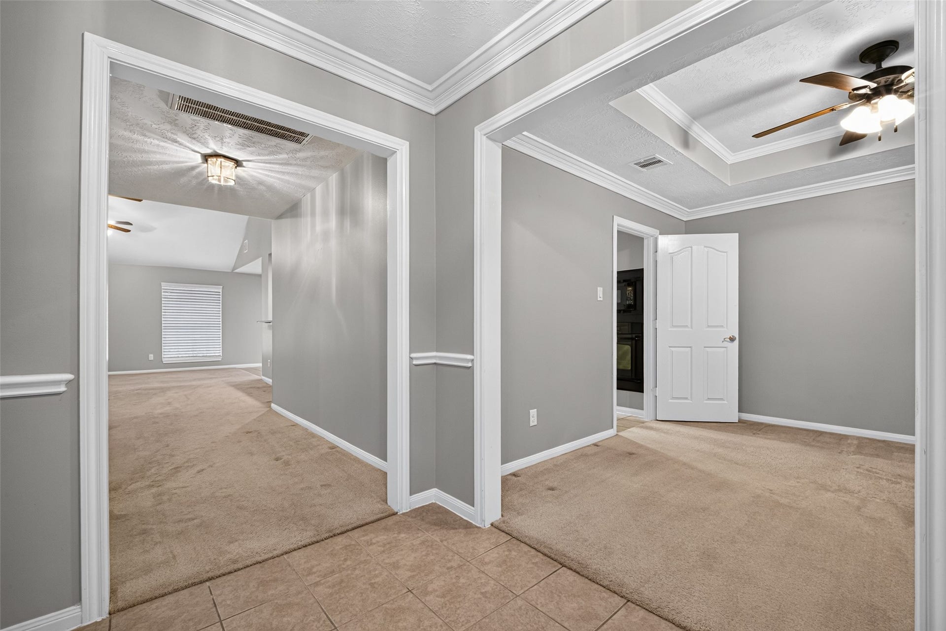 Versatile flex space featuring neutral finishes, decorative trim, and coffered ceiling details.