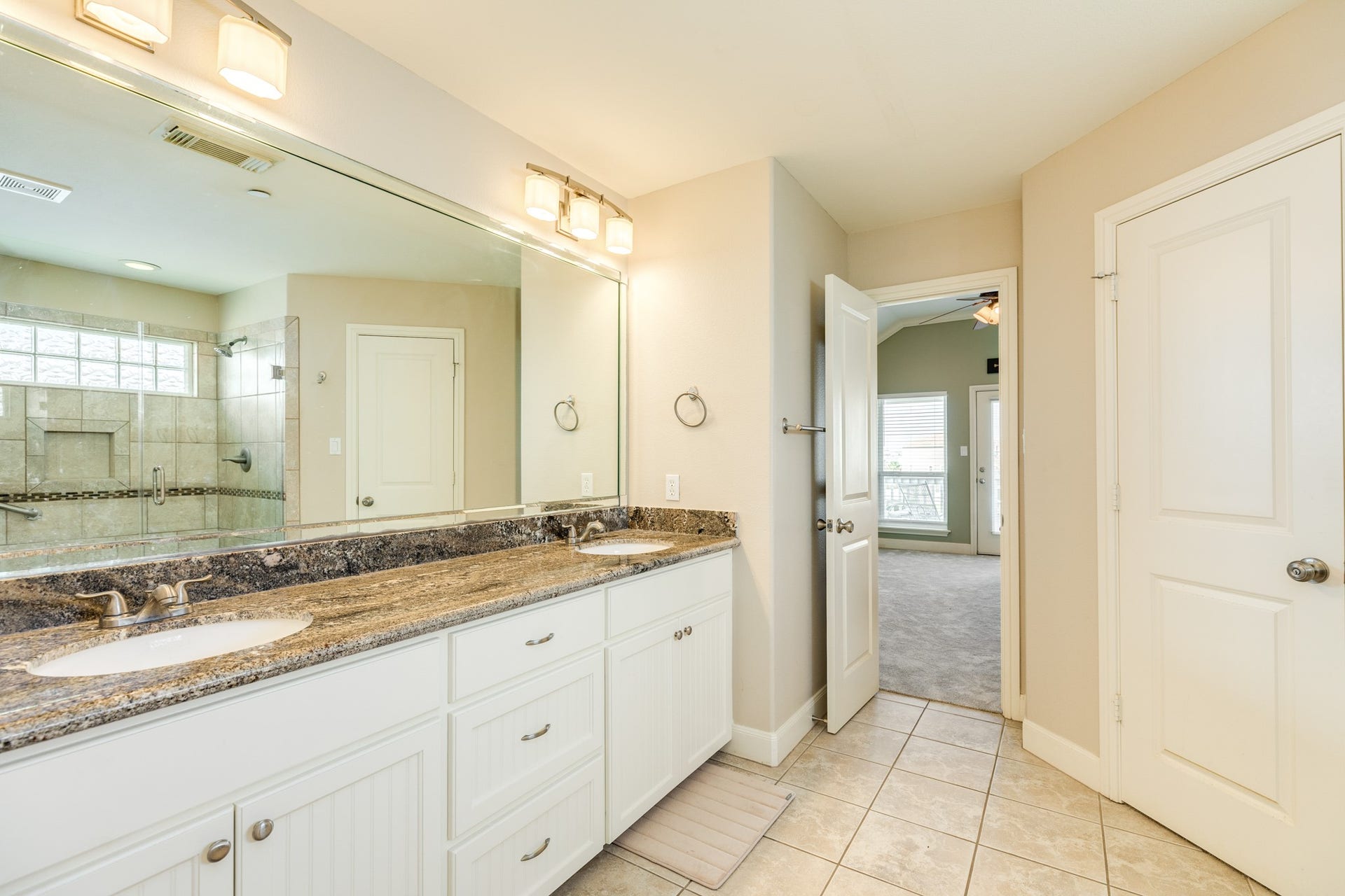 325 Admiral Circle, Tiki Island, TX 77554 Primary bath has double vanity sinks, water closet, his & her closets and a walk in shower.