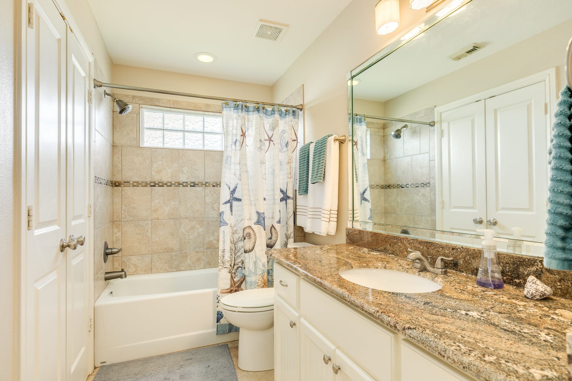 325 Admiral Circle, Tiki Island, TX 77554 Hall bathroom. The double doors to the left in this view leads into the utility closet.