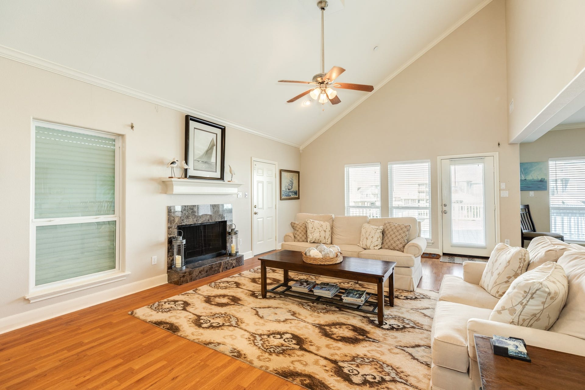 325 Admiral Circle, Tiki Island, TX 77554 View of the living room looking towards the main deck and canal system. Windows and doors provide an abundance of natural light.