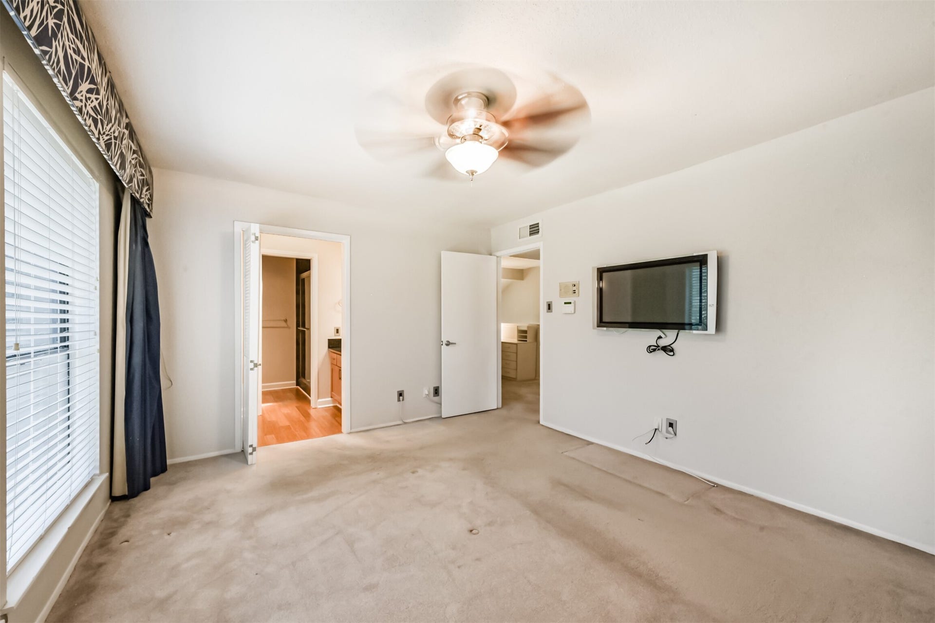 Primary bedroom- comes with TV and window treatments.