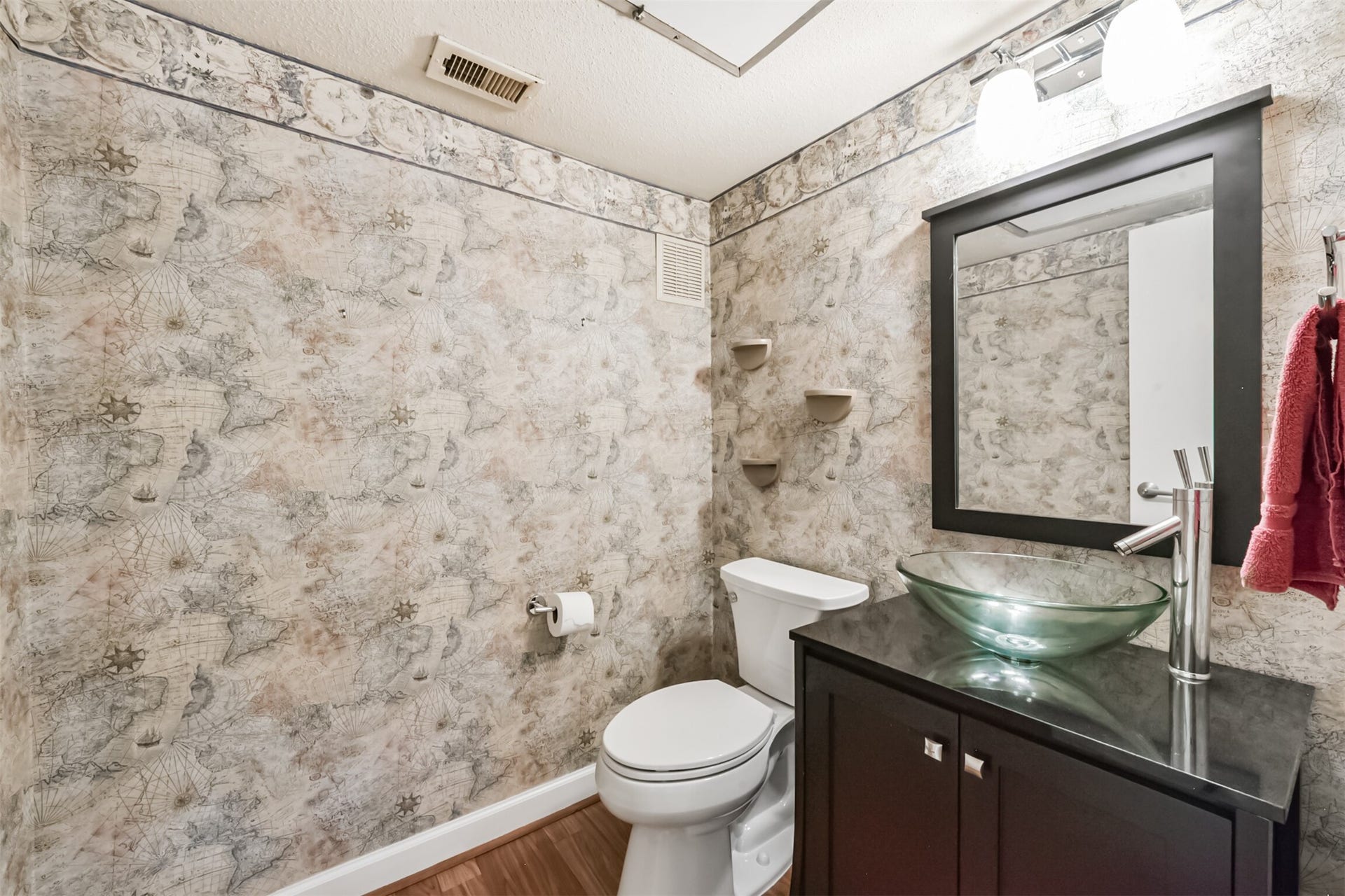 Downstairs half bath with updated vanity and bowl sink.