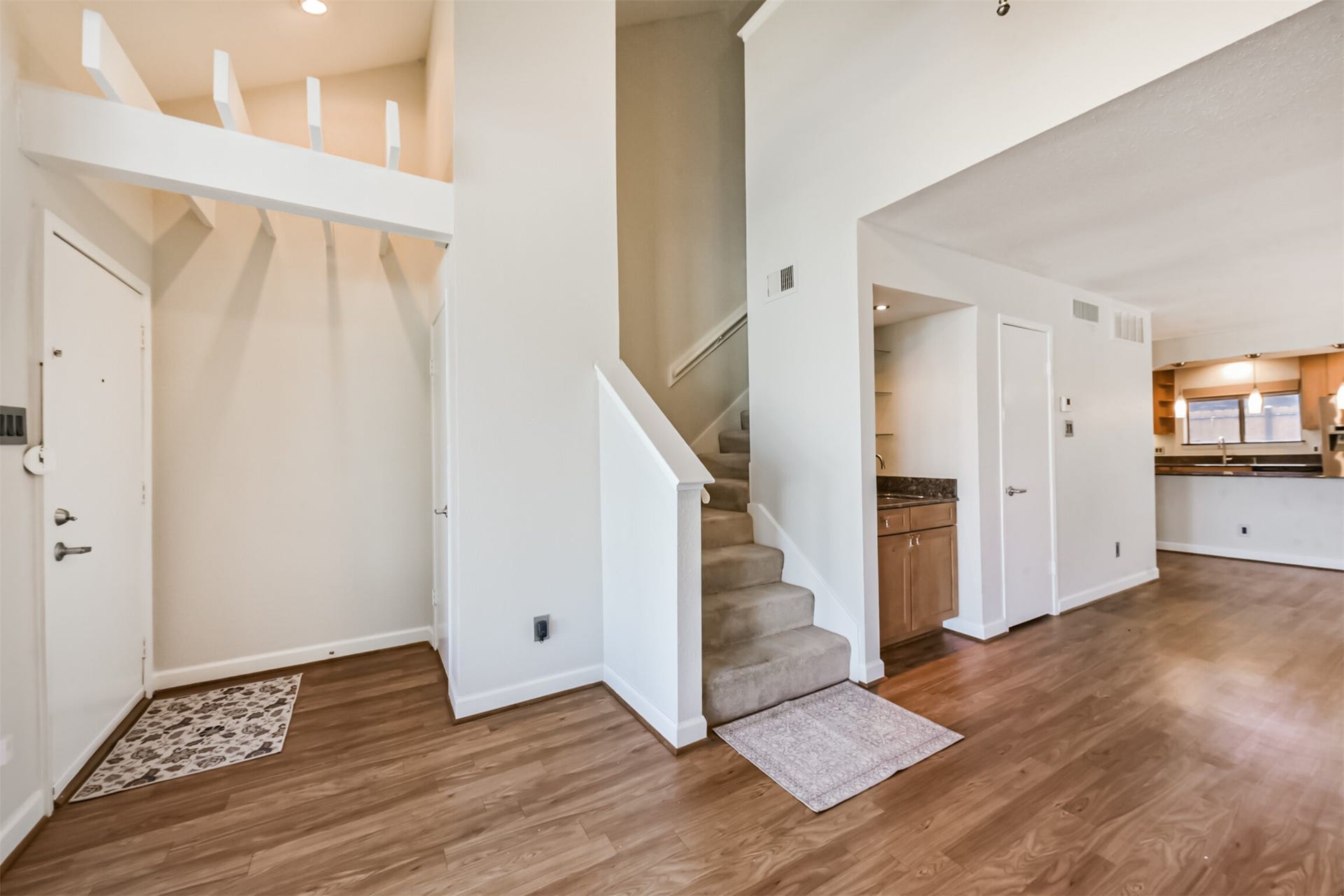 Front door and coat closet. Wet bar and understairs storage.