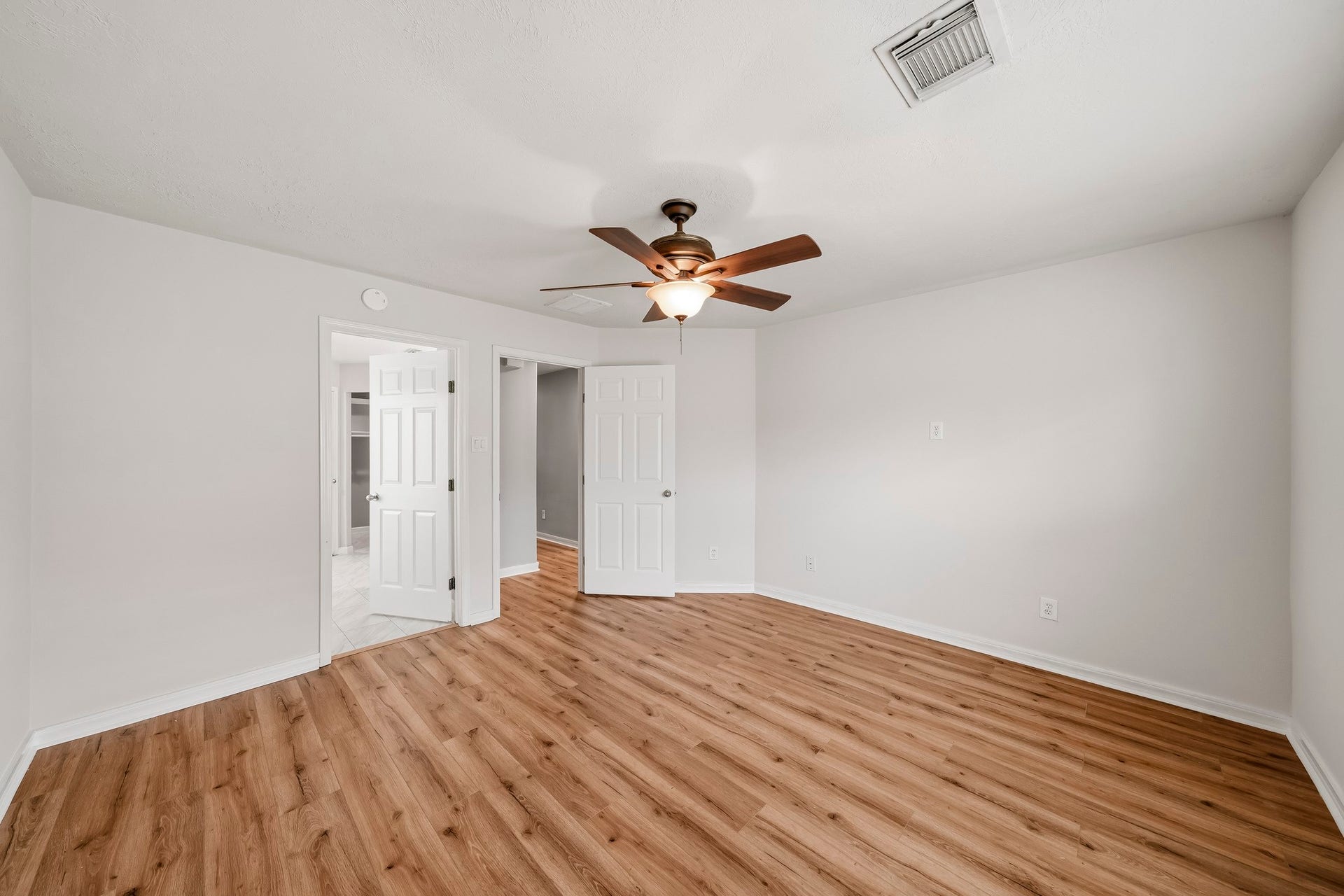 18126 Brightwood Park Lane, Richmond, TX 77407 Spacious primary bedroom features warm flooring, neutral finishes, and plenty of natural light.
