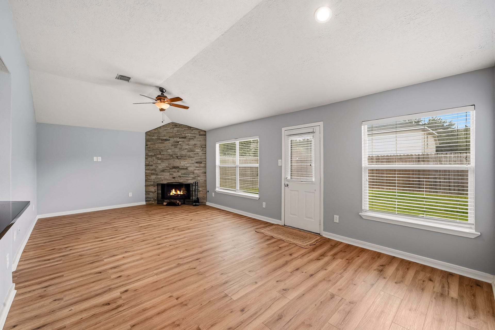 18126 Brightwood Park Lane, Richmond, TX 77407 Spacious family area features warm flooring, high ceilings, and a cozy corner fireplace.