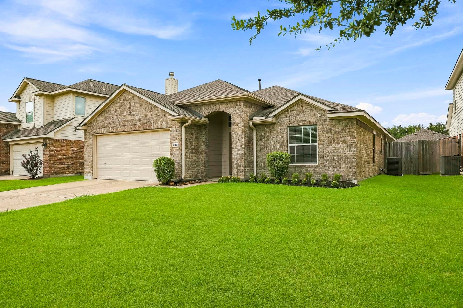18126 Brightwood Park Lane, Richmond, TX 77407 Well-maintained exterior surrounded by a spacious front lawn and mature landscaping.