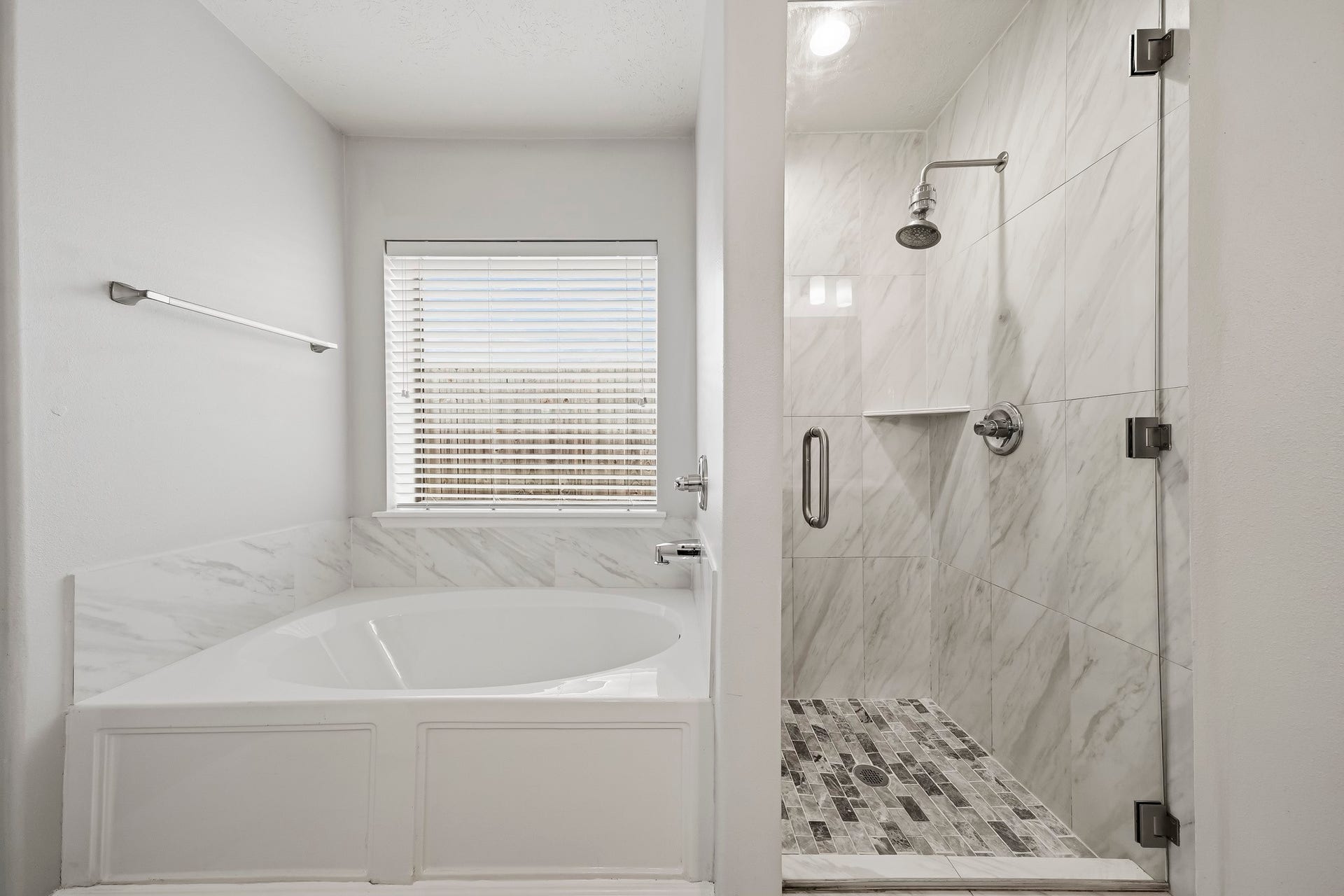 18126 Brightwood Park Lane, Richmond, TX 77407 Separate glass-enclosed shower and soaking tub create a relaxing primary bath retreat.
