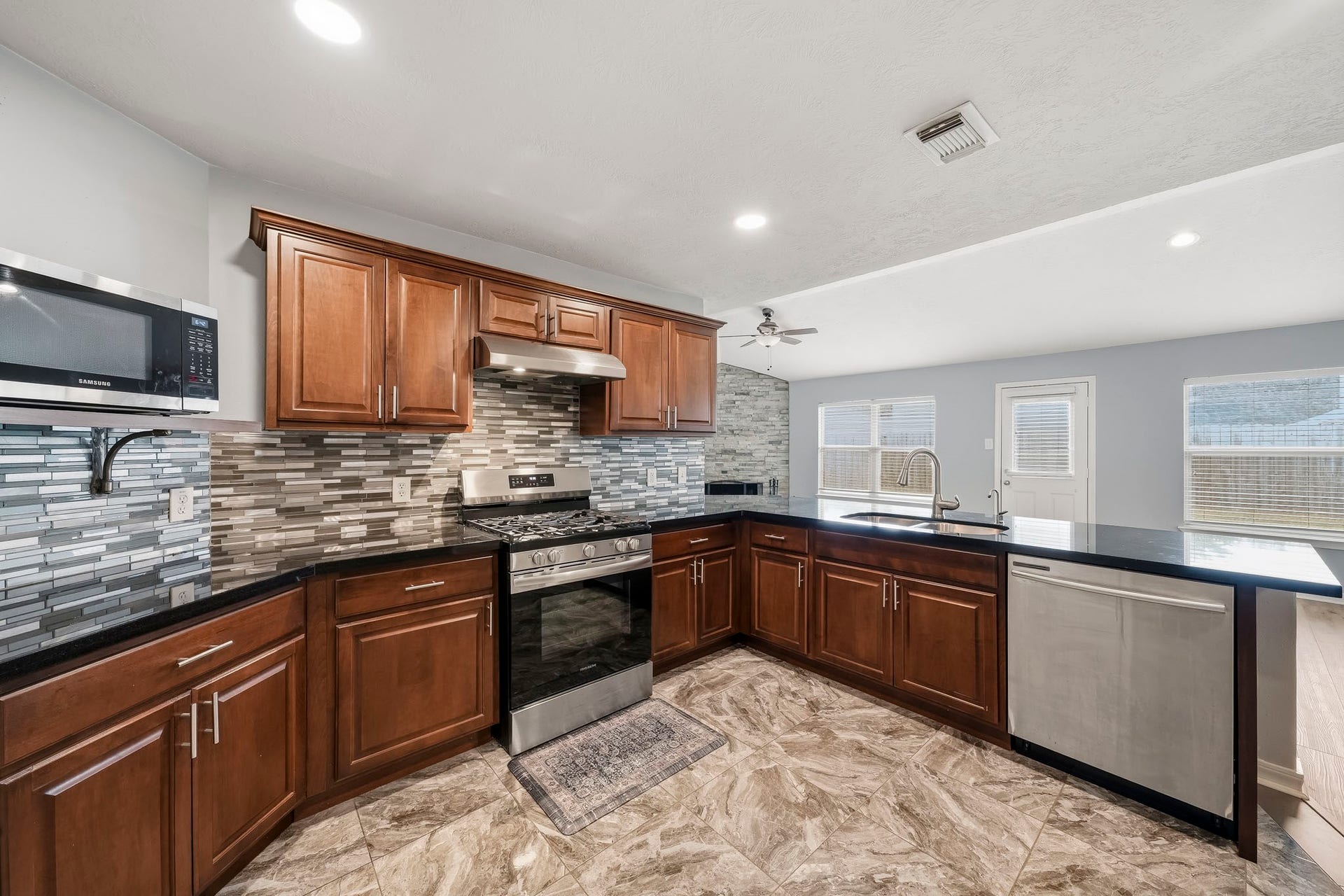 18126 Brightwood Park Lane, Richmond, TX 77407 Updated kitchen features custom cabinetry, countertops, appliances, and modern finishes.