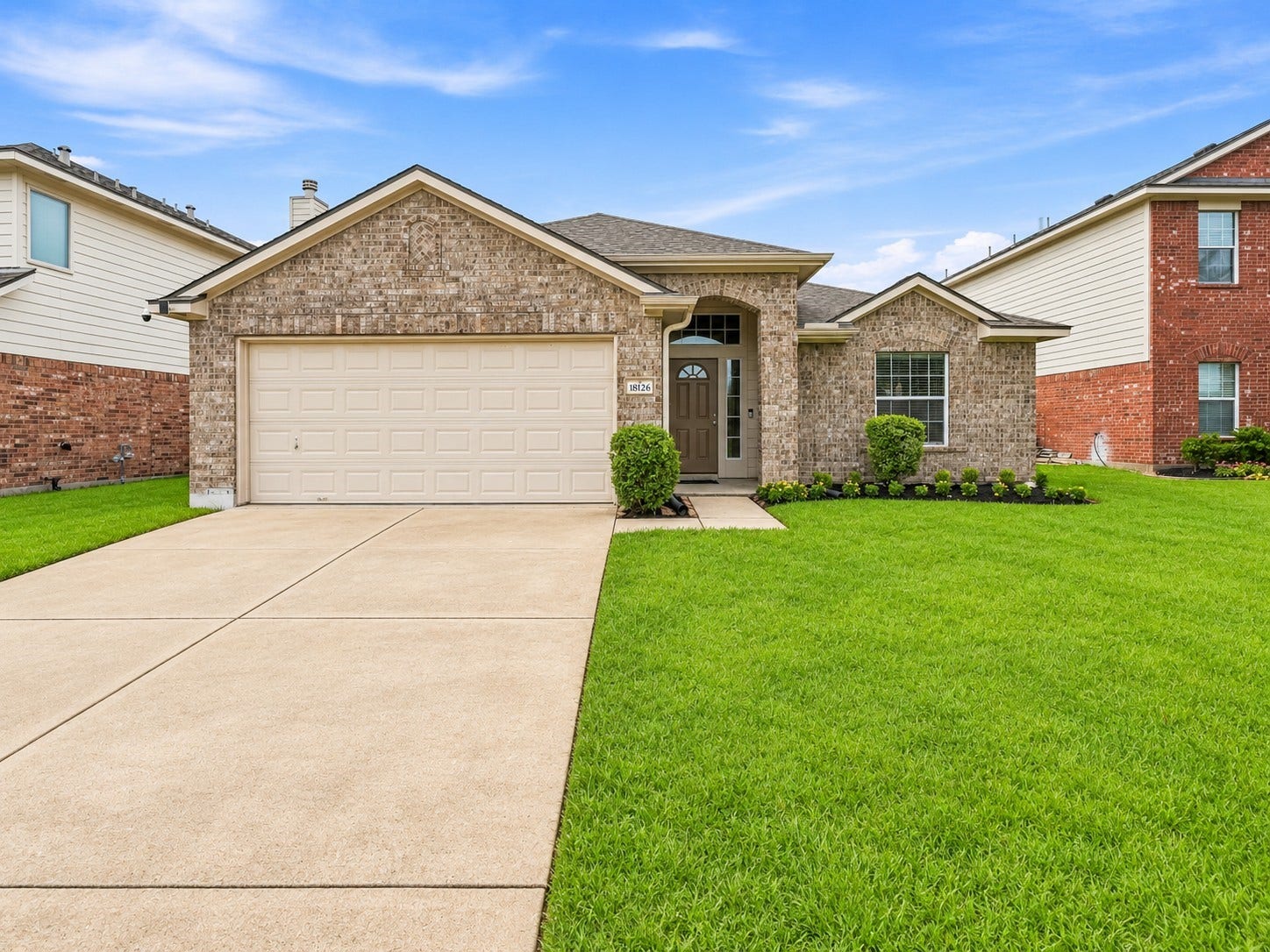 18126 Brightwood Park Lane, Richmond, TX 77407 Wide driveway provides convenient access to the attached two-car garage.