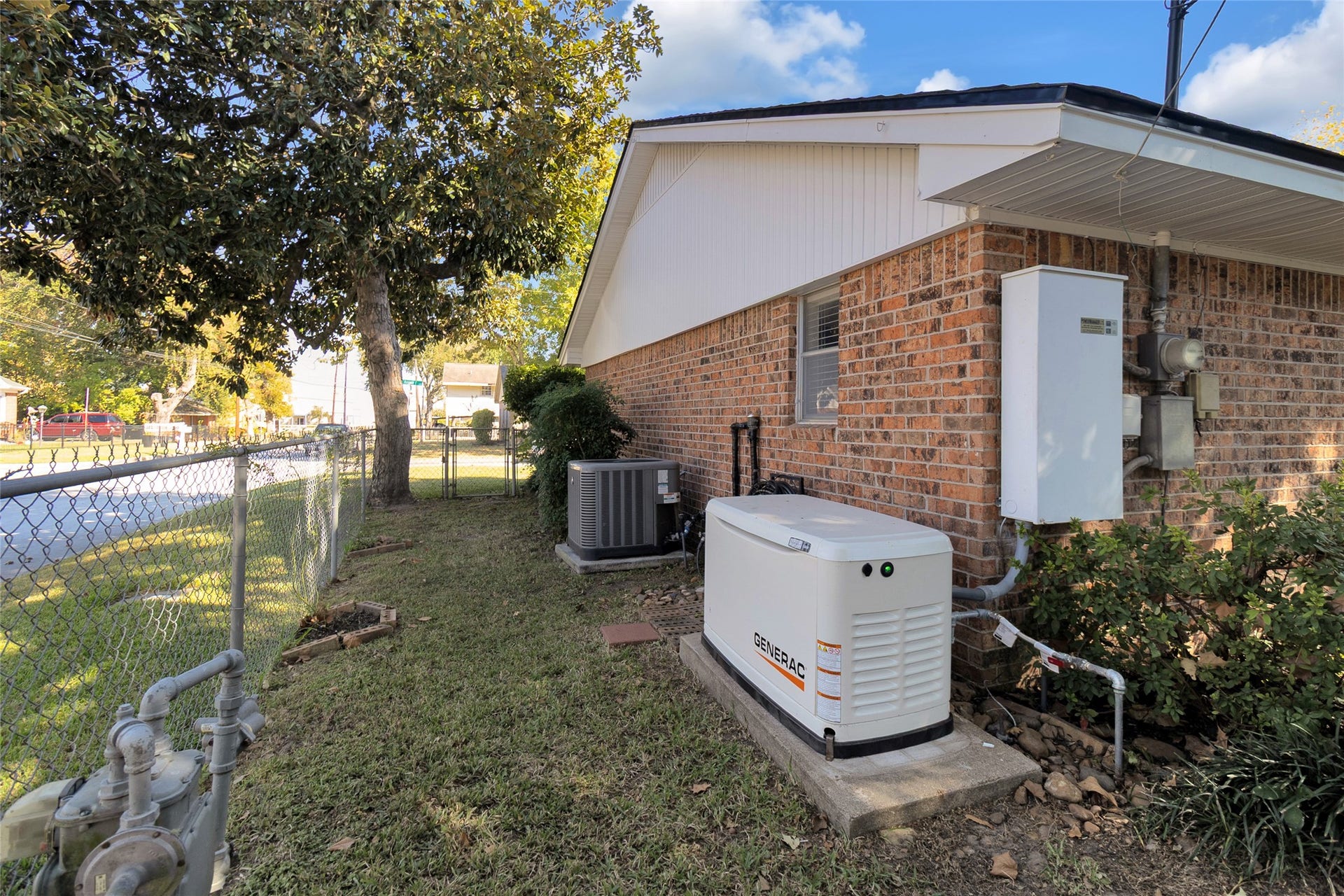 613 N Avenue F, Humble, TX 77338 Brick exterior with a well-maintained yard, featuring a standby generator and modern HVAC system for reliable comfort and energy efficiency.
