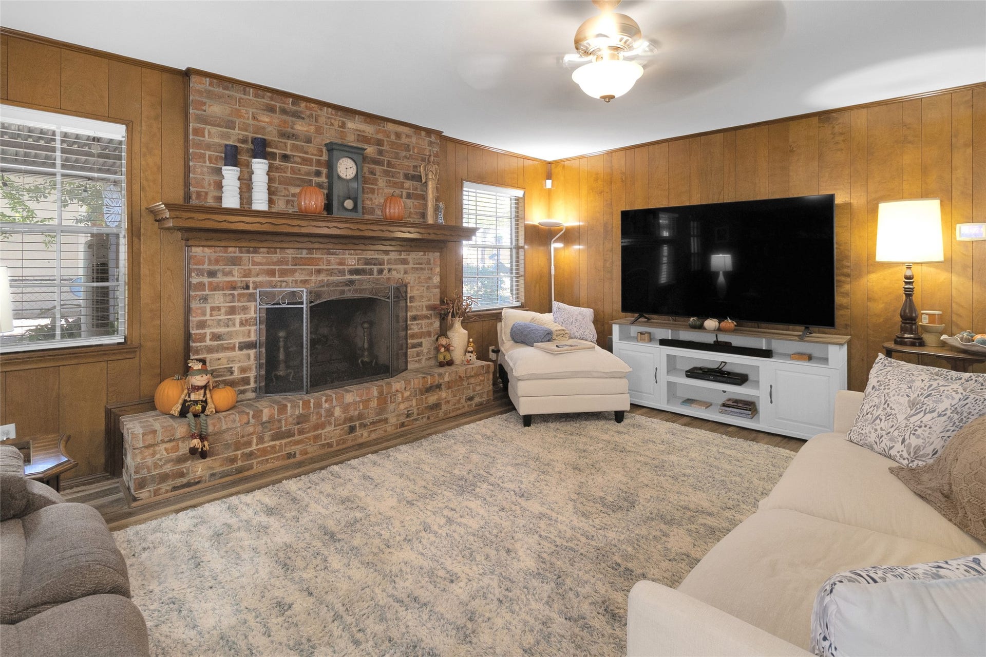 613 N Avenue F, Humble, TX 77338 Cozy living room featuring a charming brick fireplace.