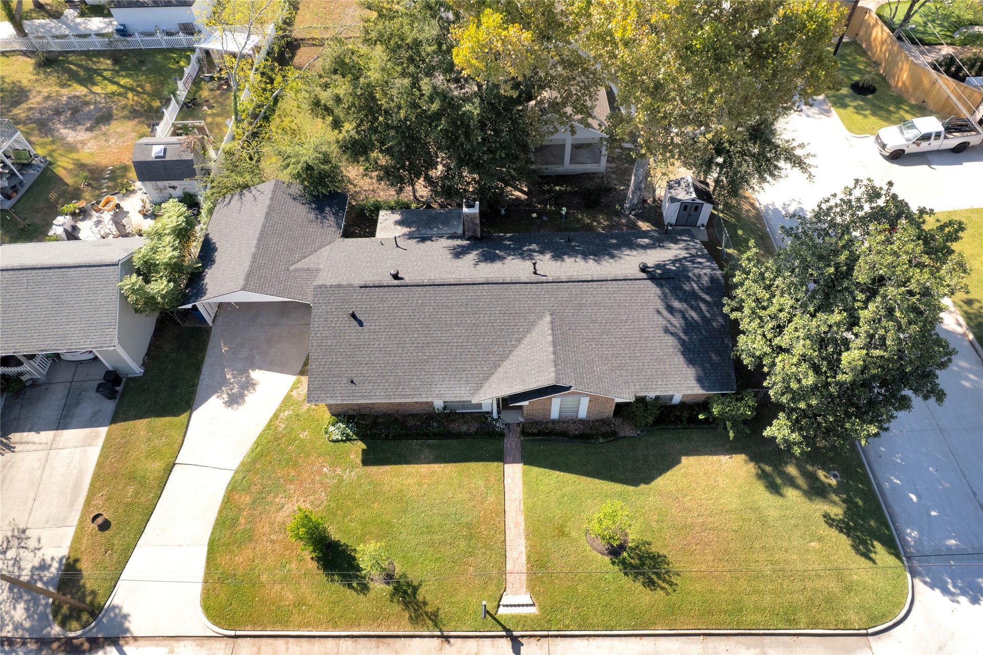 613 N Avenue F, Humble, TX 77338 Charming single-story home with a well-maintained lawn, mature trees, and a welcoming walkway leading to the entrance. The property features a spacious driveway and a cozy backyard space, perfect for outdoor enjoyment.