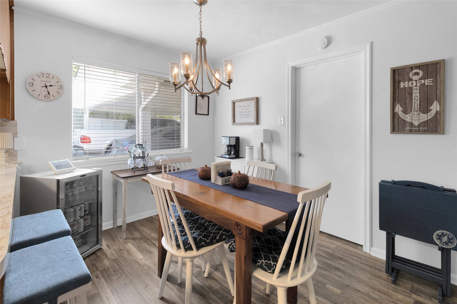 613 N Avenue F, Humble, TX 77338 Cozy breakfast area with warm wood flooring, a charming chandelier, and ample natural light from a large window, perfect for intimate gatherings.