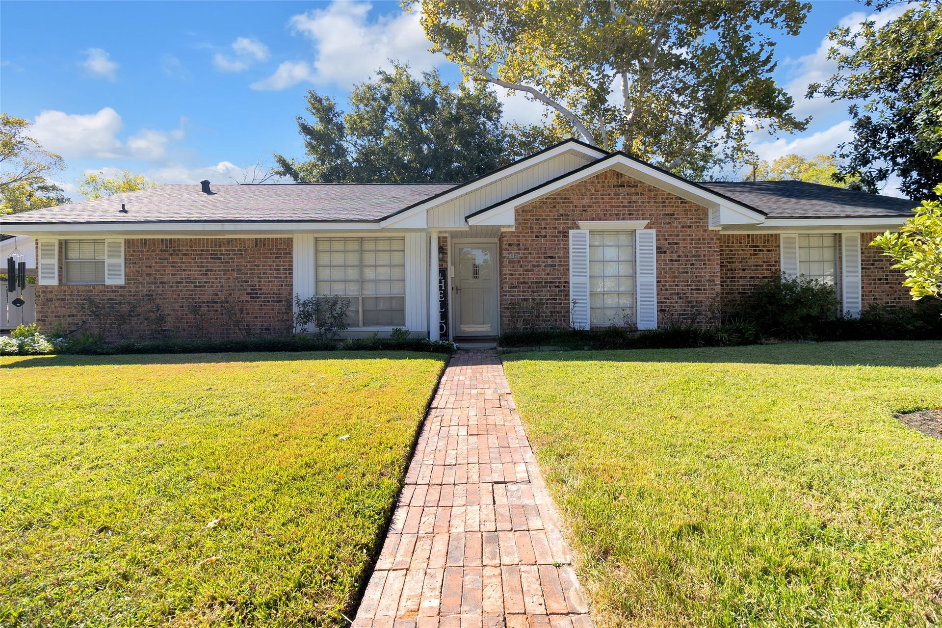 613 N Avenue F, Humble, TX 77338 Inviting front entrance featuring a welcoming walkway surrounded by beautifully maintained landscaping, enhancing the homes charming curb appeal.