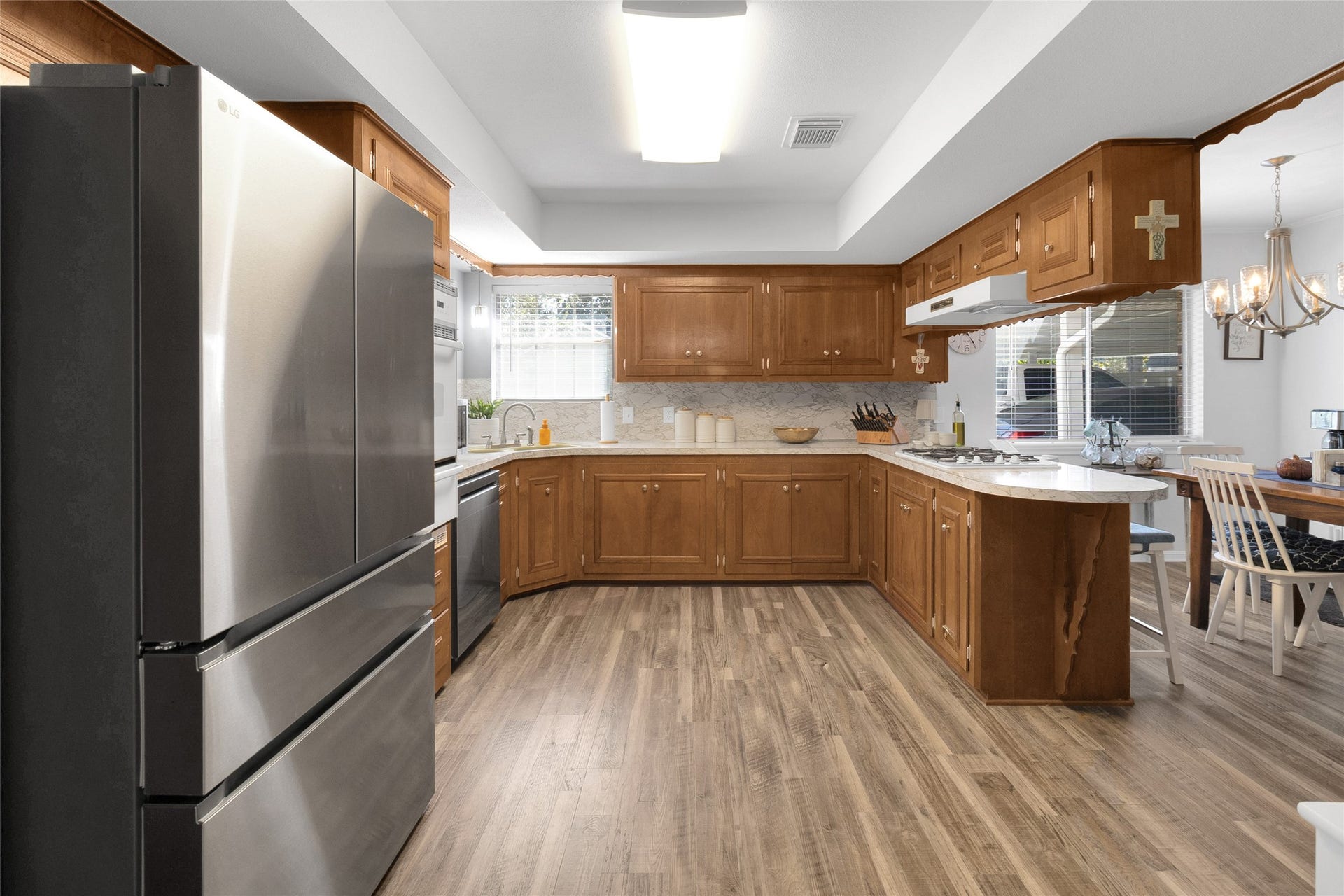 613 N Avenue F, Humble, TX 77338 Spacious kitchen featuring sleek stainless steel appliances, warm wooden cabinetry, and a cozy breakfast bar, seamlessly connected to the breakfast area for effortless entertaining.